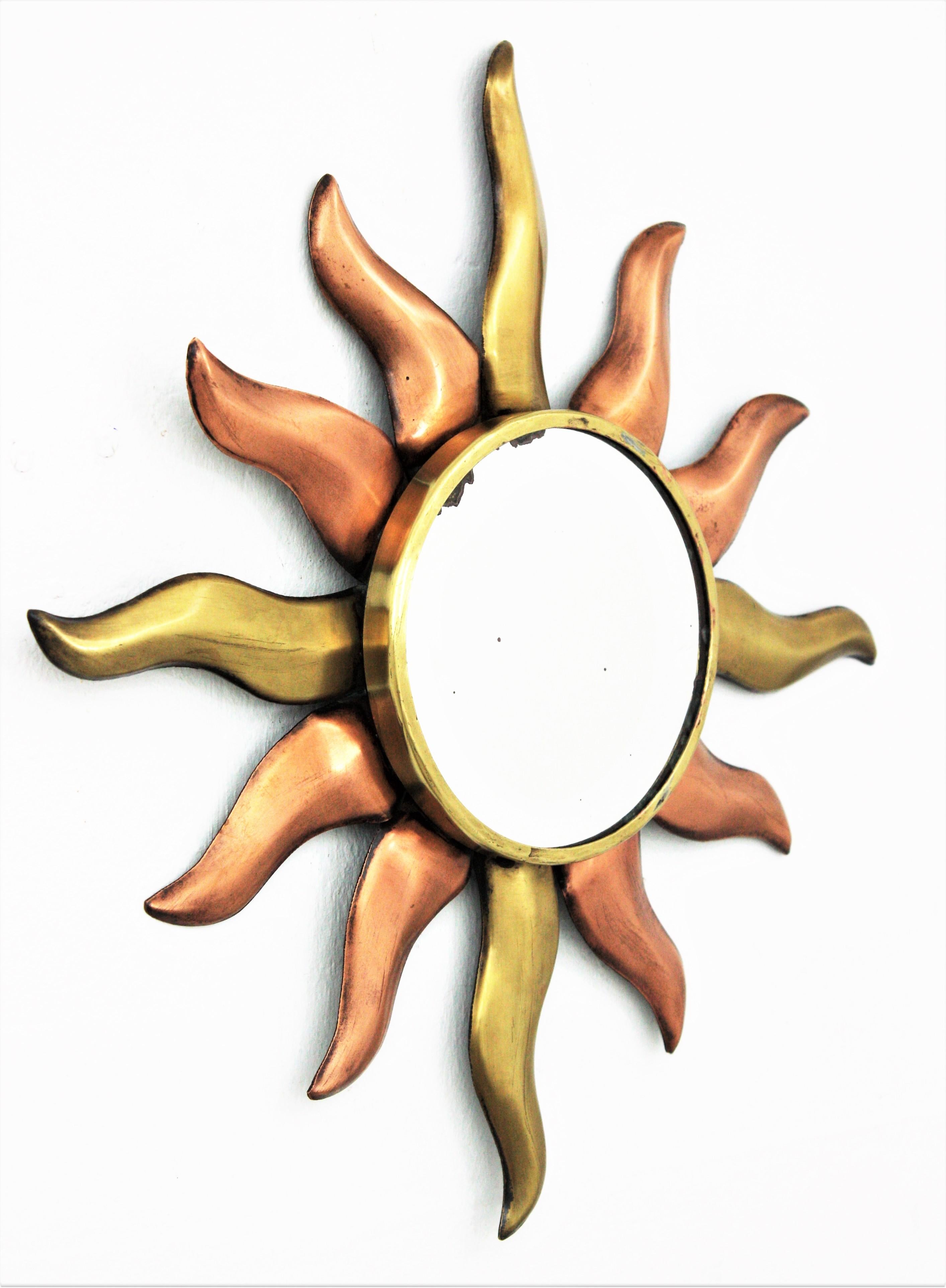 Handcrafted copper and brass small sunburst mirror. France, 1930s.
This lovely mirror features a sunburst with alternating copper and brass rays in two sizes.
Eye-catching placed alone or as a part of a sunburst wall composition.
Measures: 35 cm