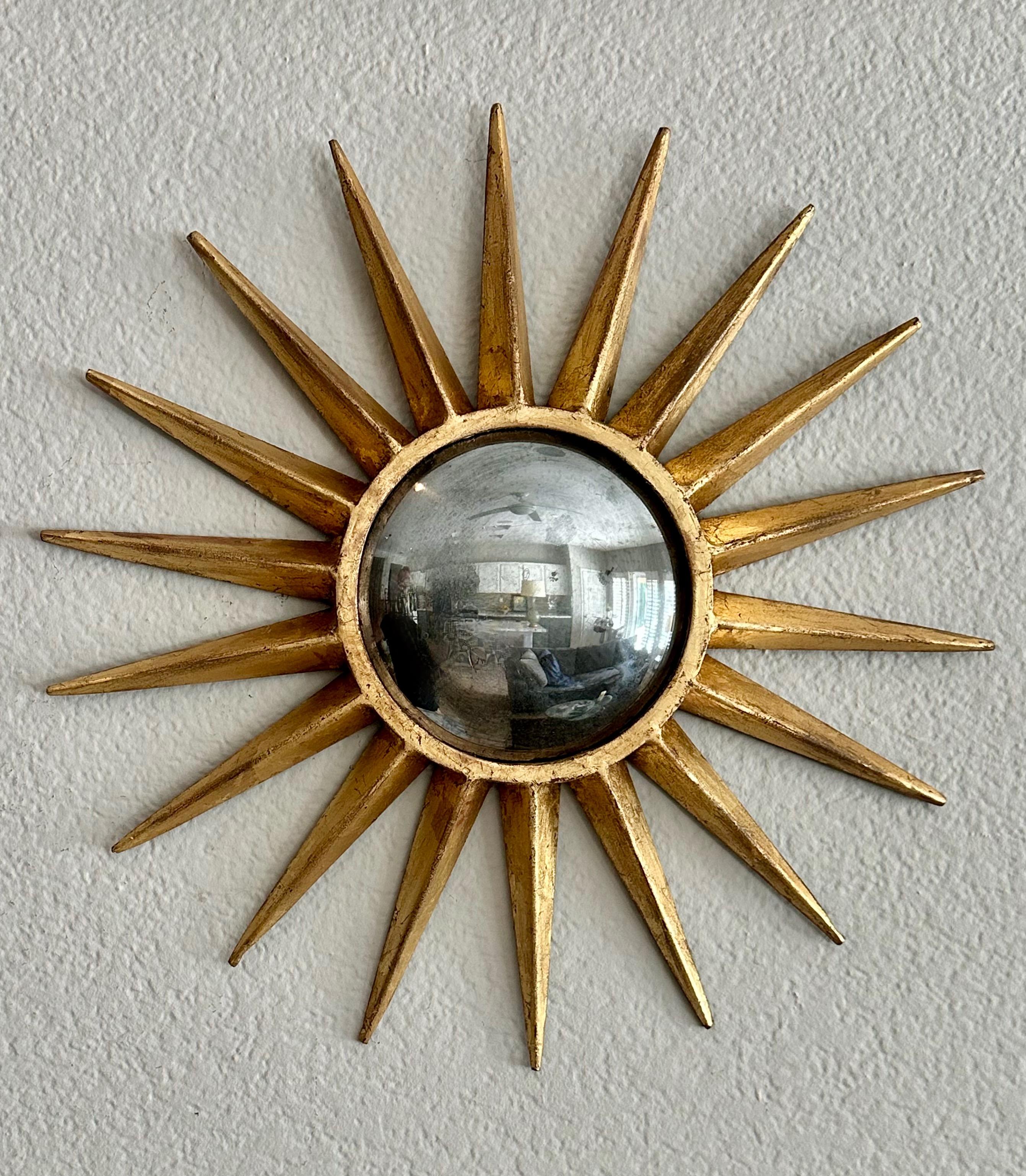 Sunburst or starburst gilt metal (steel) wall mirror with aged oxidized convex mirror. (Second available under separate listing.)