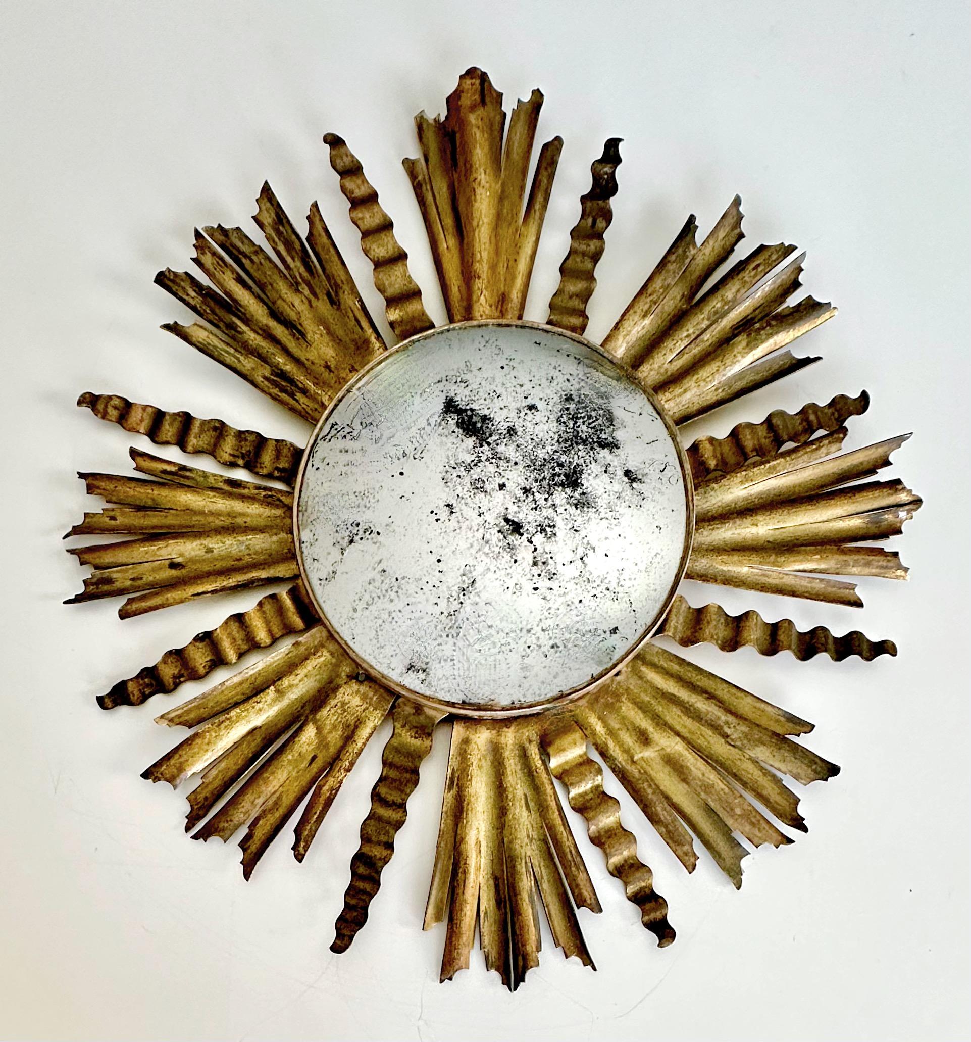 Stylized antique sunburst or starburst gilt metal wall mirror with newer aged oxidized convex mirror. 