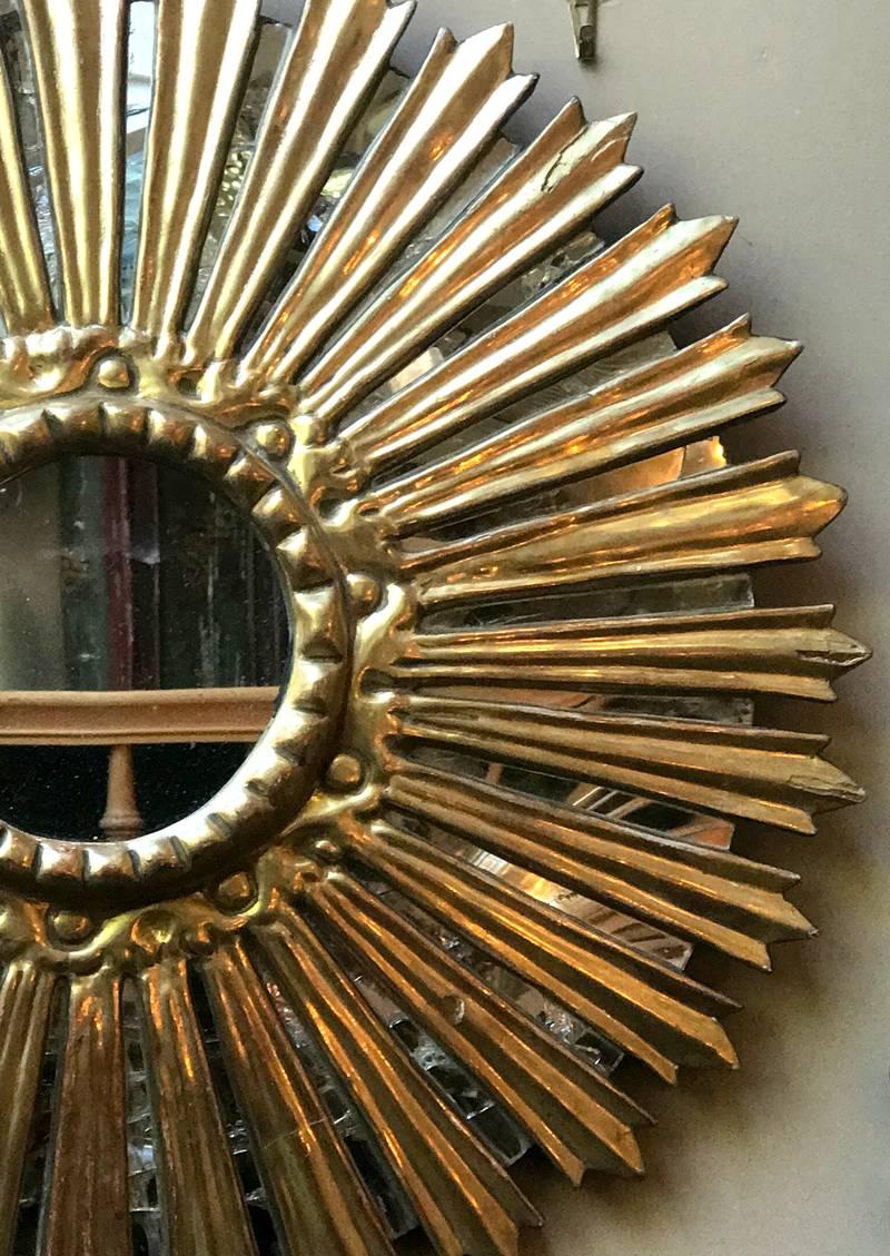 A Spanish circa 1920s gilt and carved wood mirror.

Measurements:
Diameter 20?.