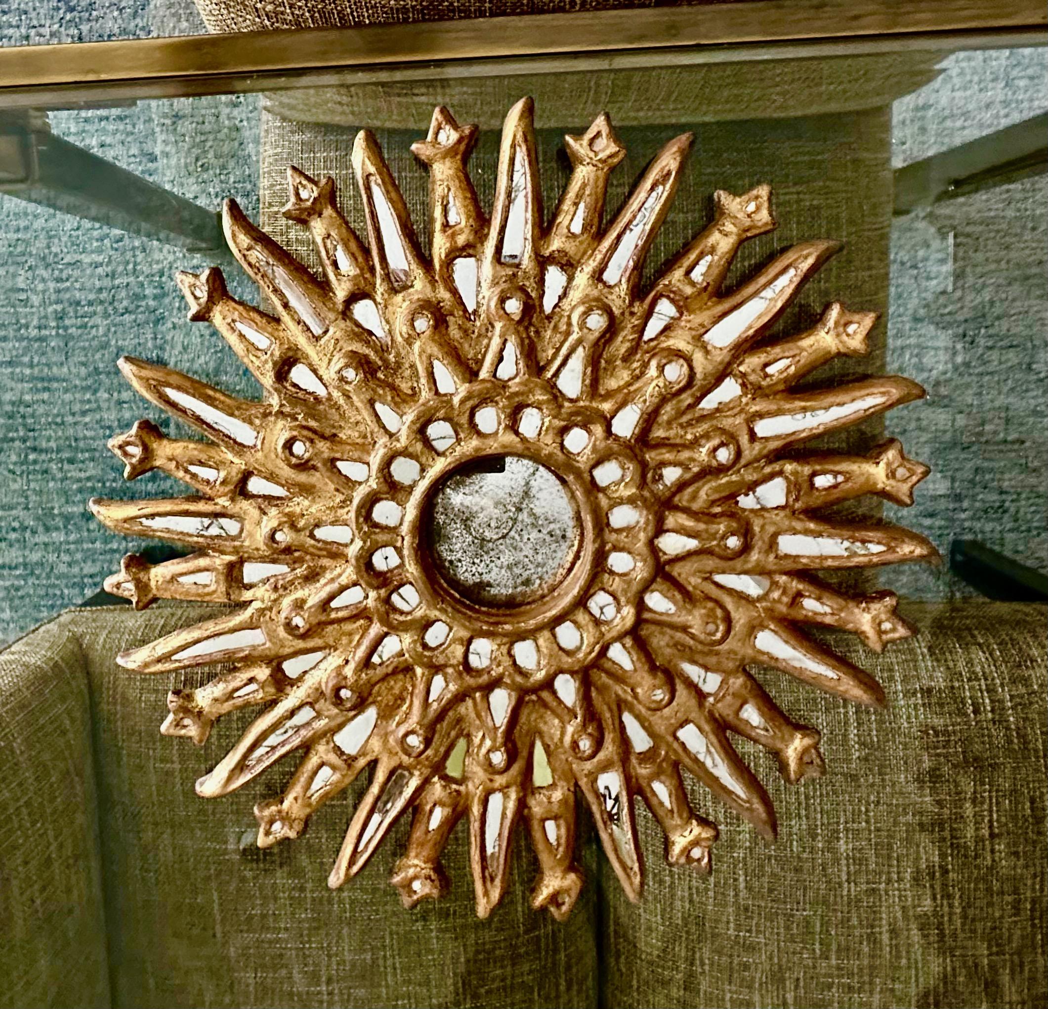Hand-carved giltwood round Colonial Spanish style wall mirror. Has smaller rows of small inset mirrors encircling the central aged convex mirror.

Measures: 20