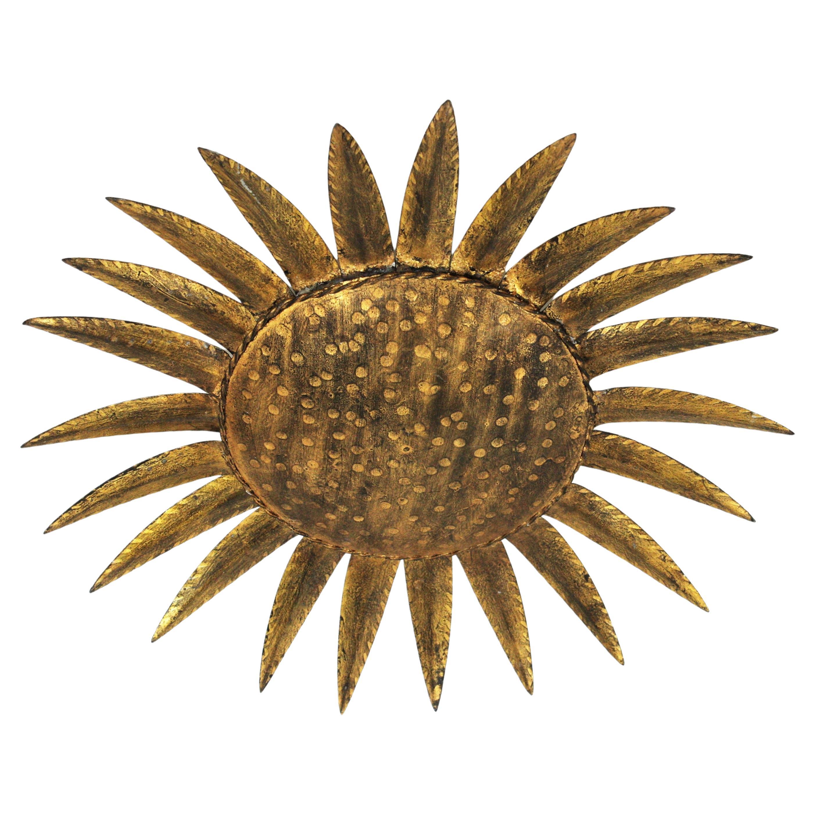 Eye-catching gilt wrought iron sunburst ceiling flush mount in the style of Brutalism. Manufactured by Ferro Art, Spain, 1950s.
Heavily adorned by the hammer marks, It has a terrific aged patina showing its original gold leaf gilding.
This