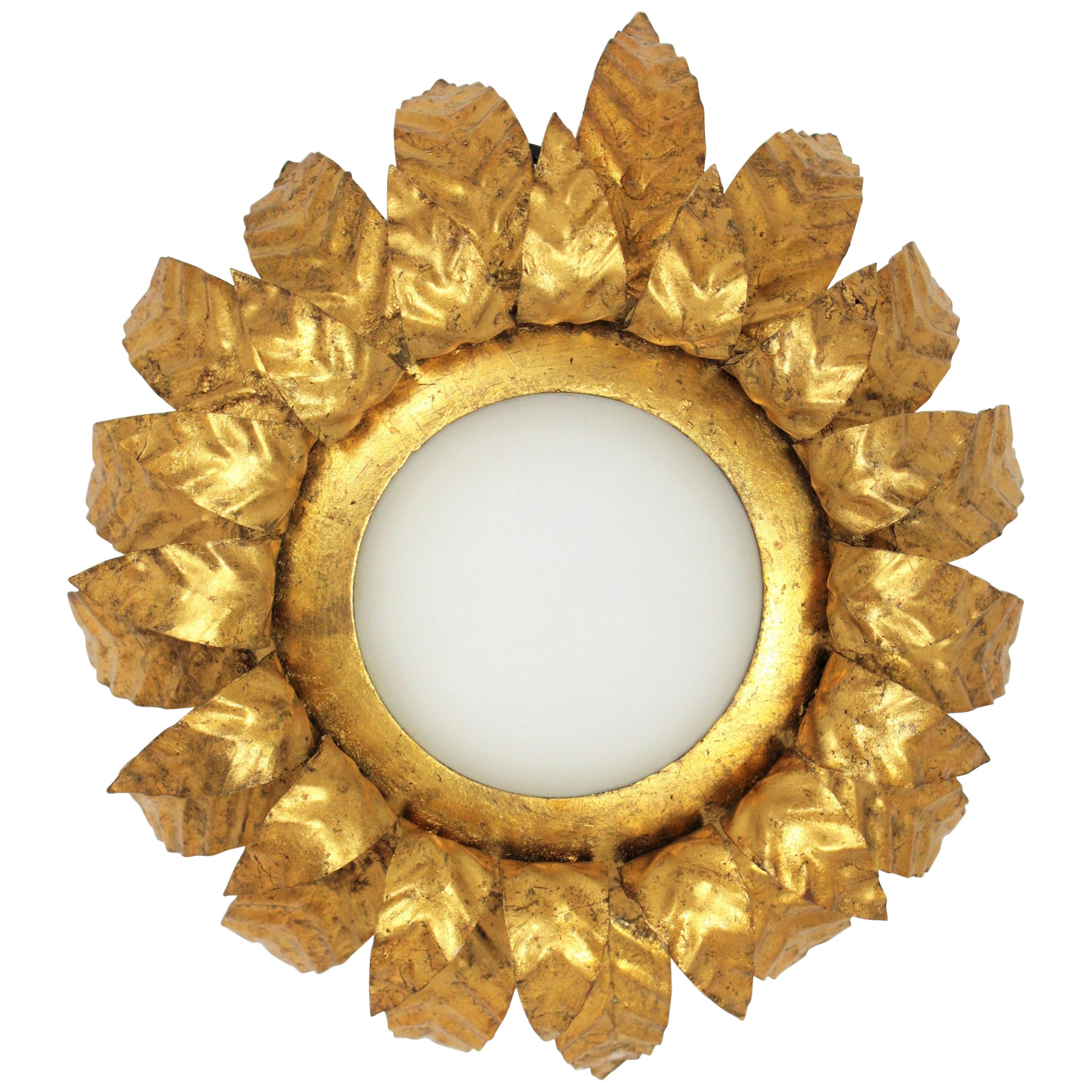 Eye-catching double layered sunburst foliage light fixture with opaline glass shade. Spain, 1950s.
It has an elegant desing and a nice color and patina showing its original gold leaf finishing.
This piece will be a good choice and a lovely