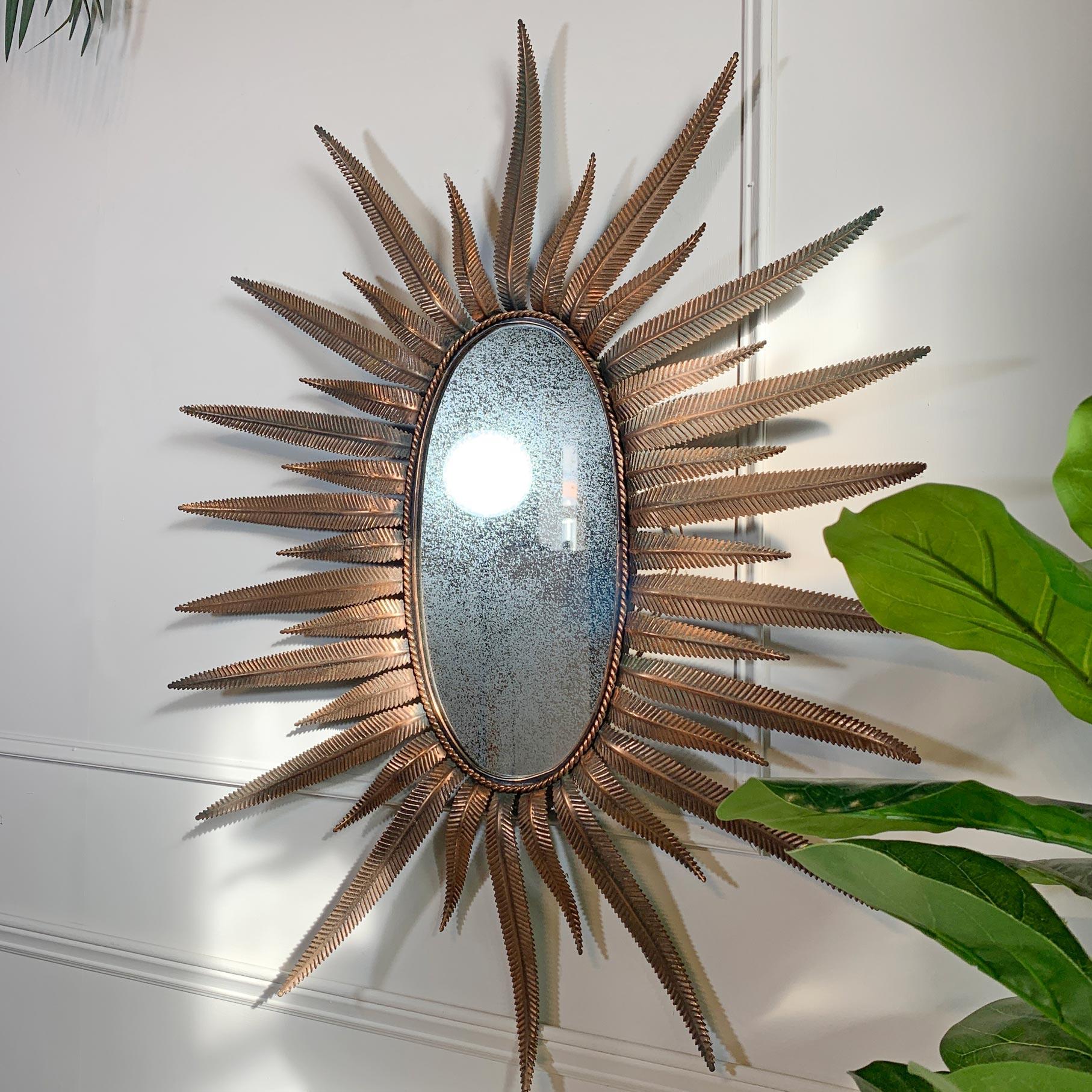 A beautiful large sunburst mirror, the hand worked feathered copper rays alternating in size around the oval mirror plate, which is original to the mirror.

Dating to the early 1970's, and made in Italy, there is some oxidisation to the rear of the