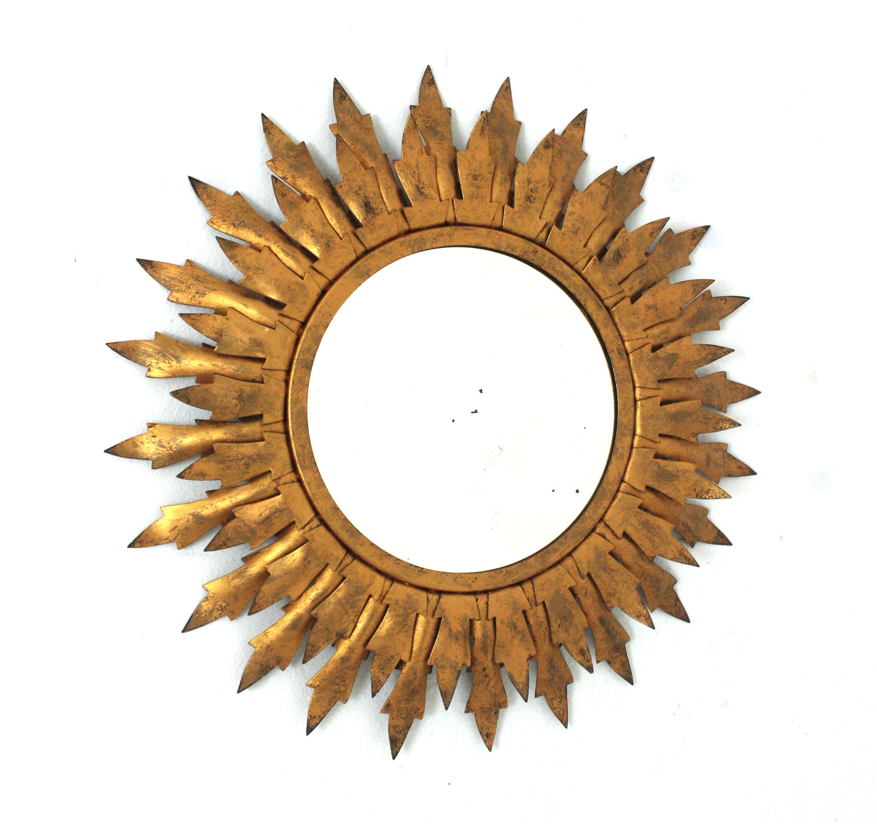 Sunburst Mirror in Gilt Metal with Double Leafed Frame
Round Sunburst mirror, Gilt iron. Spain, 1950s
______
This iron sunburst wall mirror features a double layered round frame with scalloped leaves surrounding the glass. Patinated in golden color.