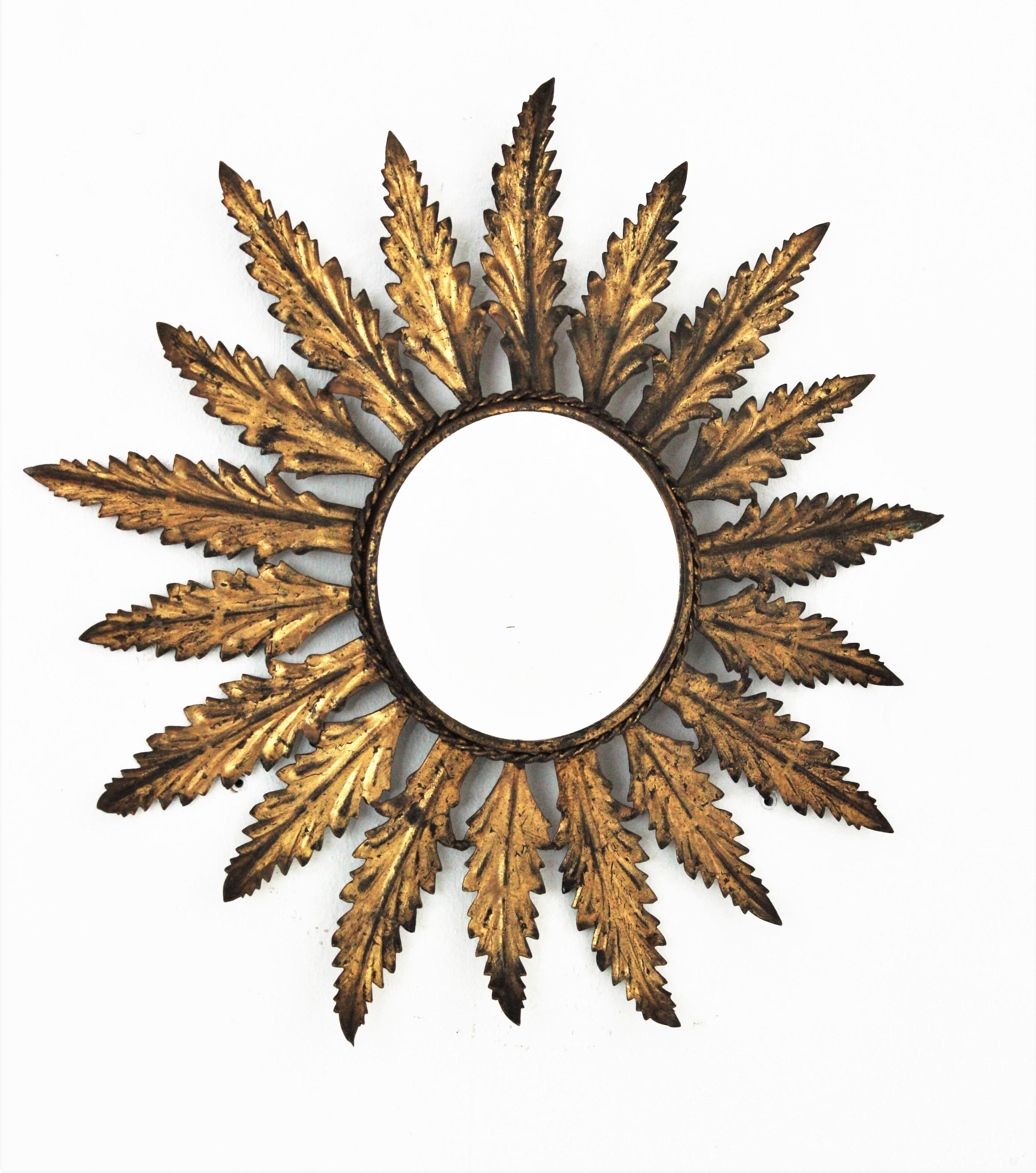 A beautiful handcrafted gilt iron sunburst mirror with alternating leaf motif and gold leaf finish. Spain, 1950s.
It has a nice leafed / foliate design and a terrific original gold leaf gilding aged patina.
Interestind placed alone or as a part of