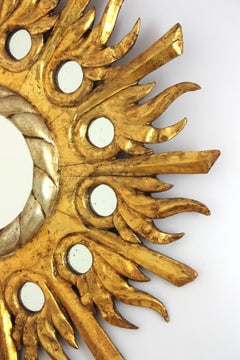 Espejo Sunburst de madera tallada dorada y plateada con inserciones de espejo, años 40