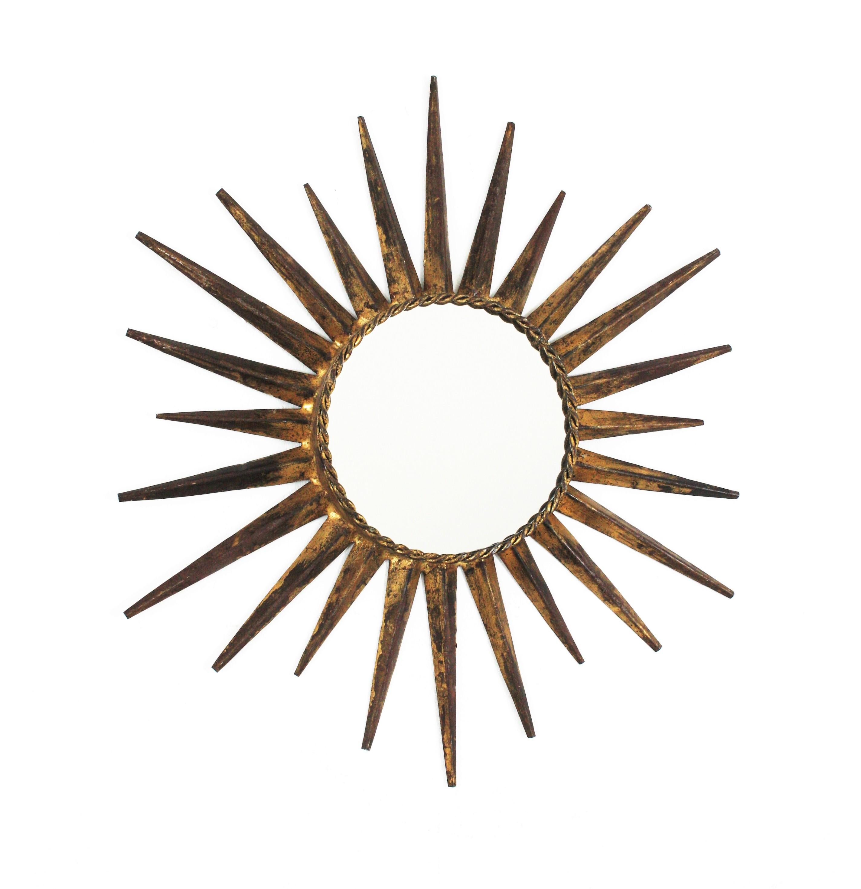 Sunburst starburst mirror in the manner of Gilbert Poillerat, Gilt Wrought Iron. France, 1940s.
This wall mirror has an eye-catching starburst design. Entirely made by hand in wrought iron and finished in gold leaf.t.
Terrific aged patina and