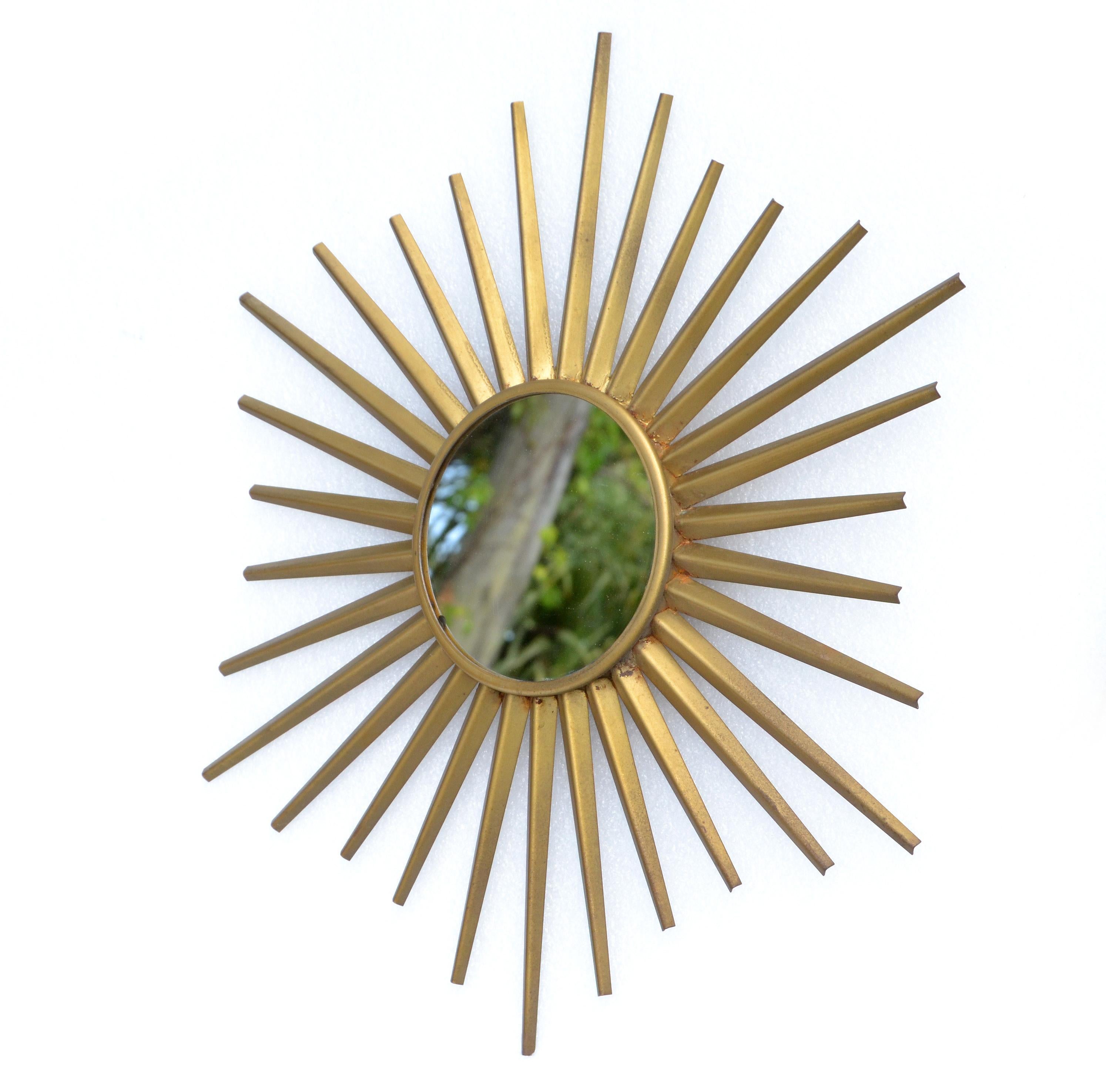 Miroir en forme de soleil en fer, finition dorée, fabriqué à la main et datant des années 1950.
Le miroir rond et plat au centre mesure 5,25 pouces de diamètre.
Le support est en bois.