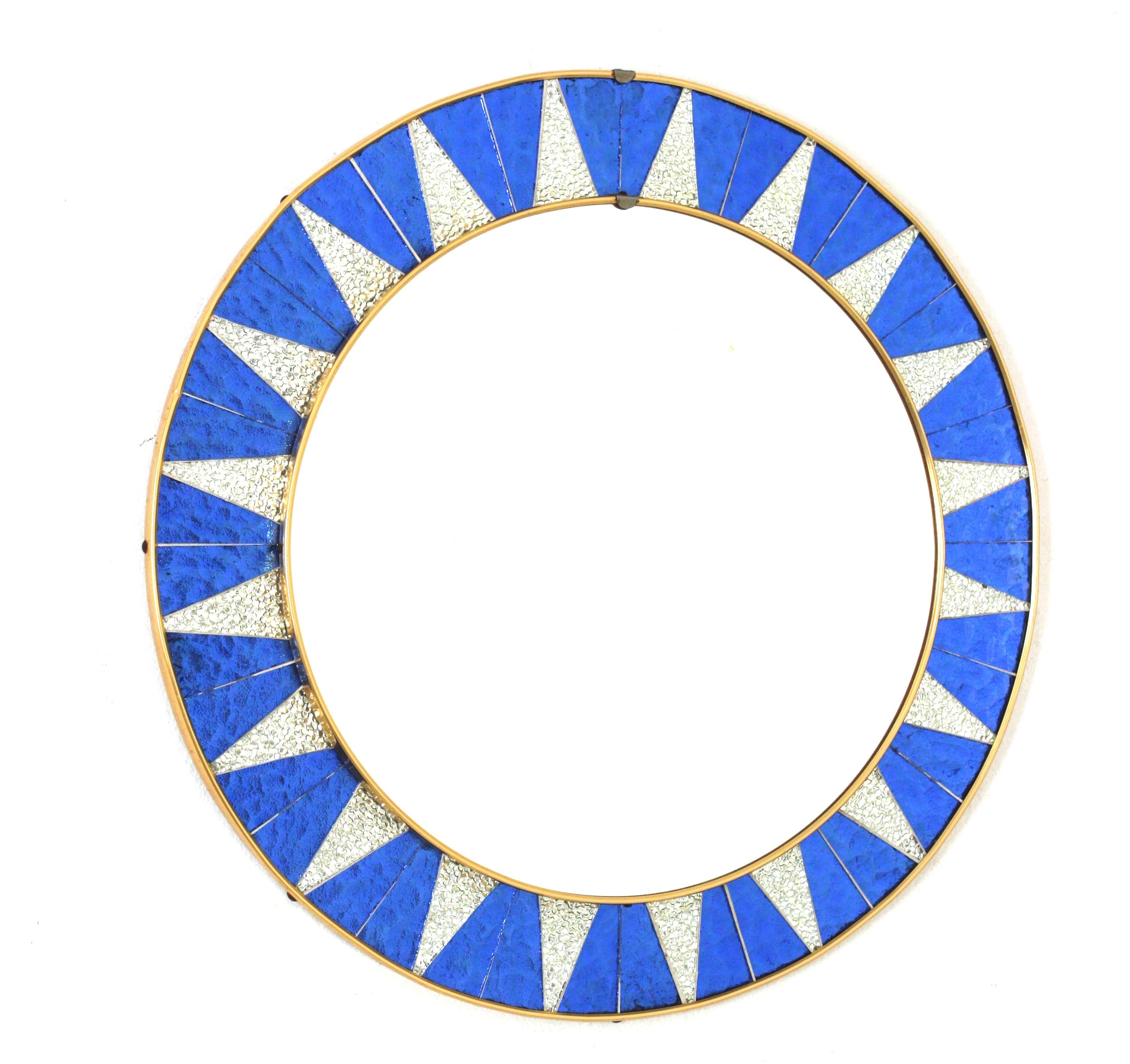 Midcentury Round Sunburst Mosaic Mirror, 
A highly decorative Mid-Century Modern circular mirror with a frame composed by pieces of textured glass silvered mirrors and iridiscent blue glasses distributed creating a sunburst pattern. Spain, circa