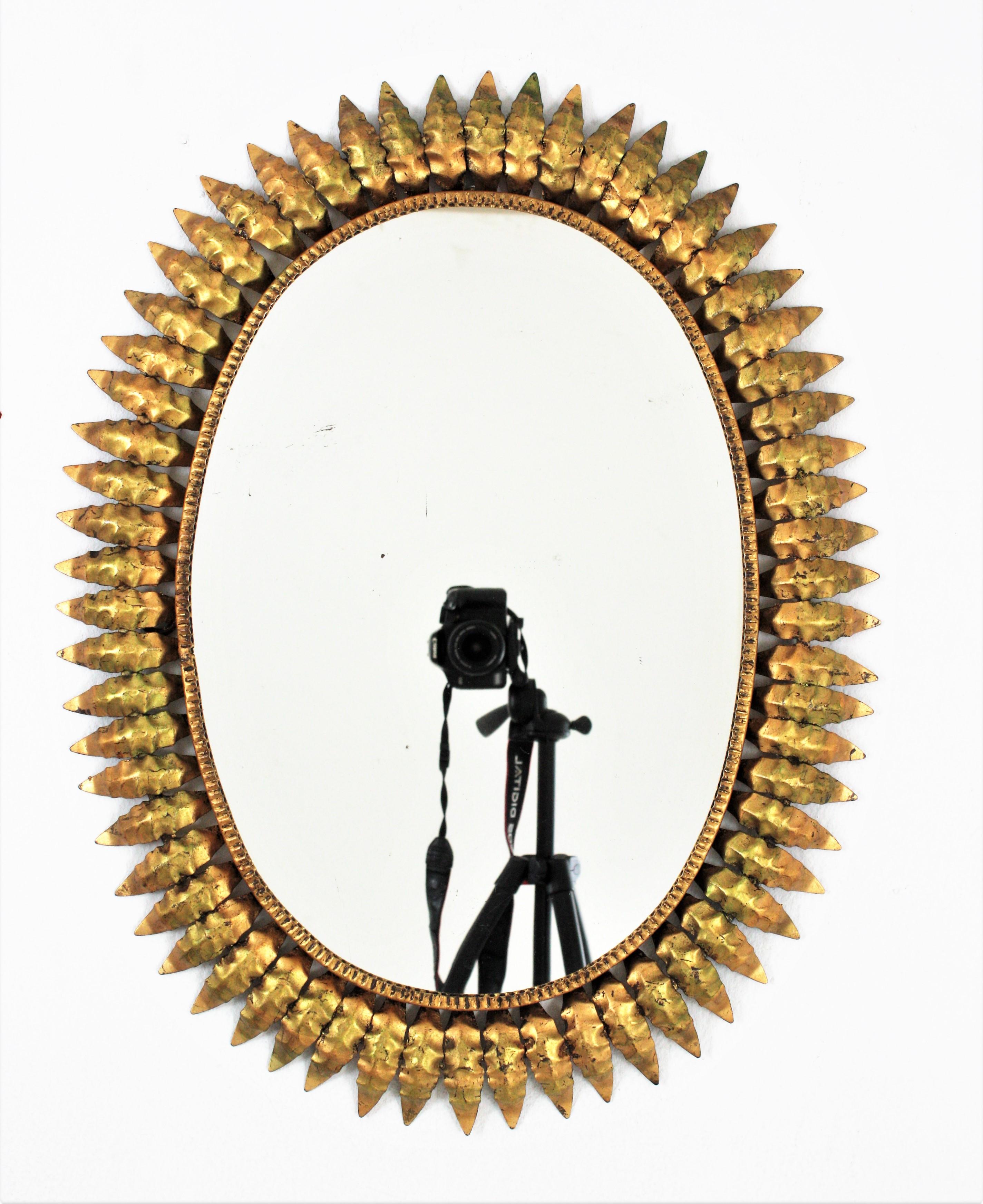 Spanischer ovaler Spiegel mit Sonnenschliff aus vergoldetem Eisen, 1950er Jahre (Moderne der Mitte des Jahrhunderts) im Angebot