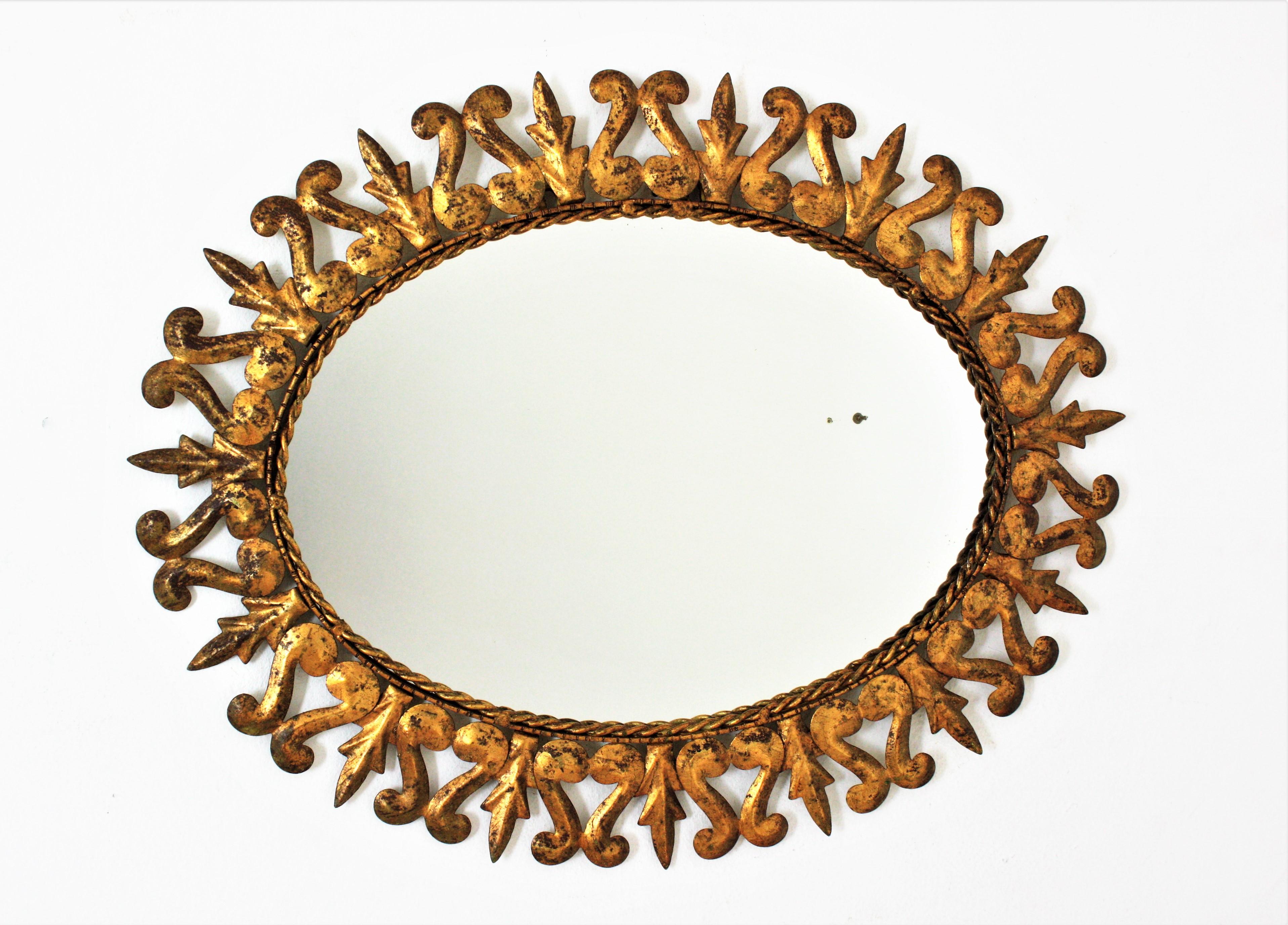 Ovaler Sonnenschliff-Spiegel aus vergoldetem Metall, Rahmen mit Schnörkeln und Blattmotiv, Spanien, 1950er Jahre  (Spanisch) im Angebot