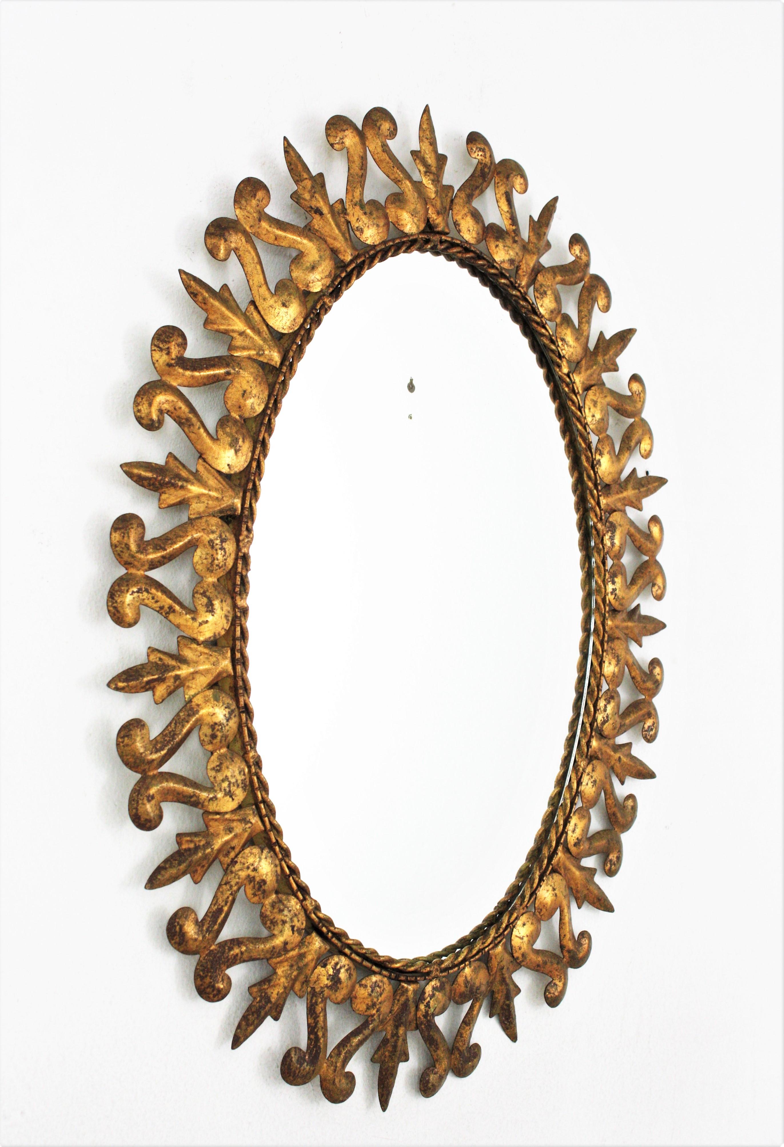 Ovaler Sonnenschliff-Spiegel aus vergoldetem Metall, Rahmen mit Schnörkeln und Blattmotiv, Spanien, 1950er Jahre  im Zustand „Gut“ im Angebot in Barcelona, ES