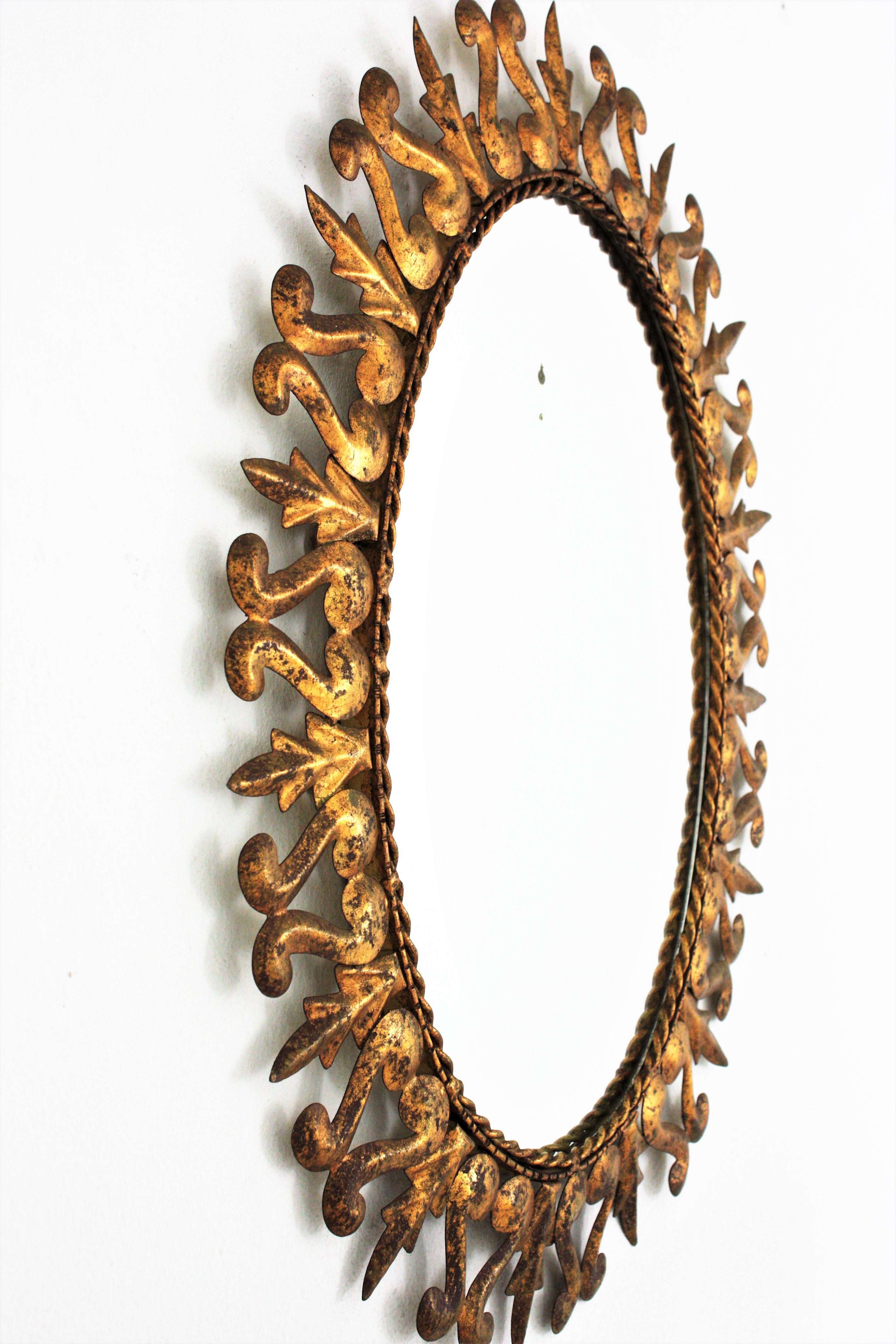 Ovaler Sonnenschliff-Spiegel aus vergoldetem Metall, Rahmen mit Schnörkeln und Blattmotiv, Spanien, 1950er Jahre  (20. Jahrhundert) im Angebot