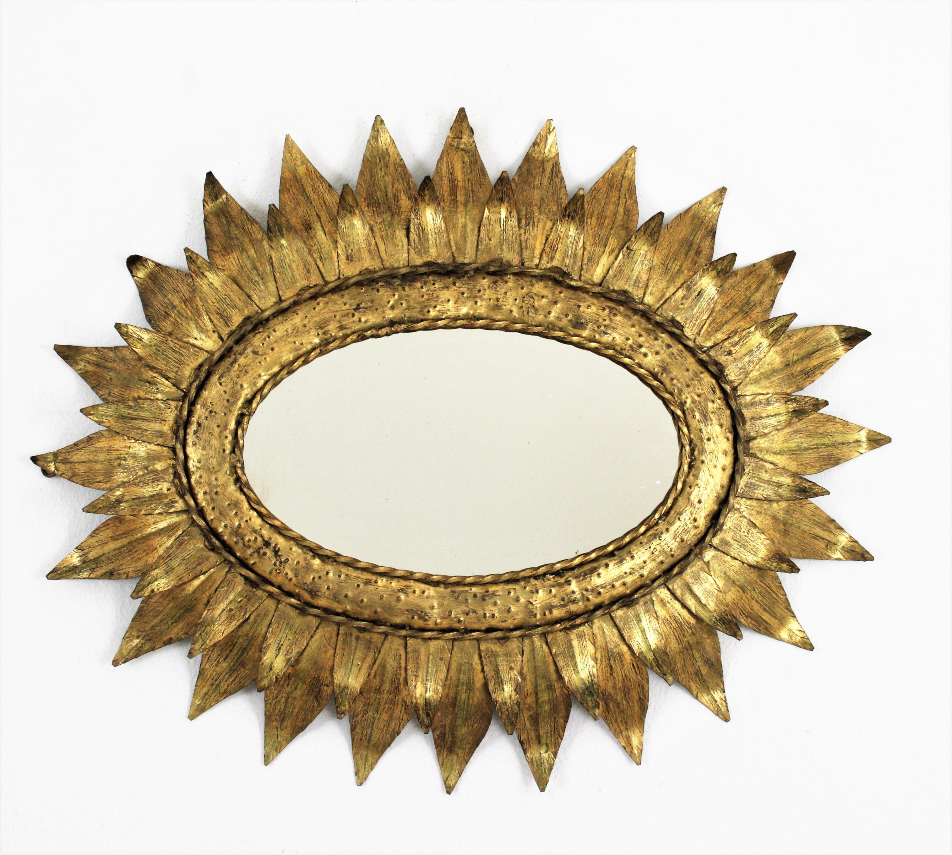 French Sunburst Oval Mirror in Gilt Metal with Double Leafed Frame, 1950s
Oval sunburst mirror, Gilt iron. France, 1950s
______
This hand-hammered iron sunburst wall mirror features a double leafed oval frame heavily adorned by the hammer marks at