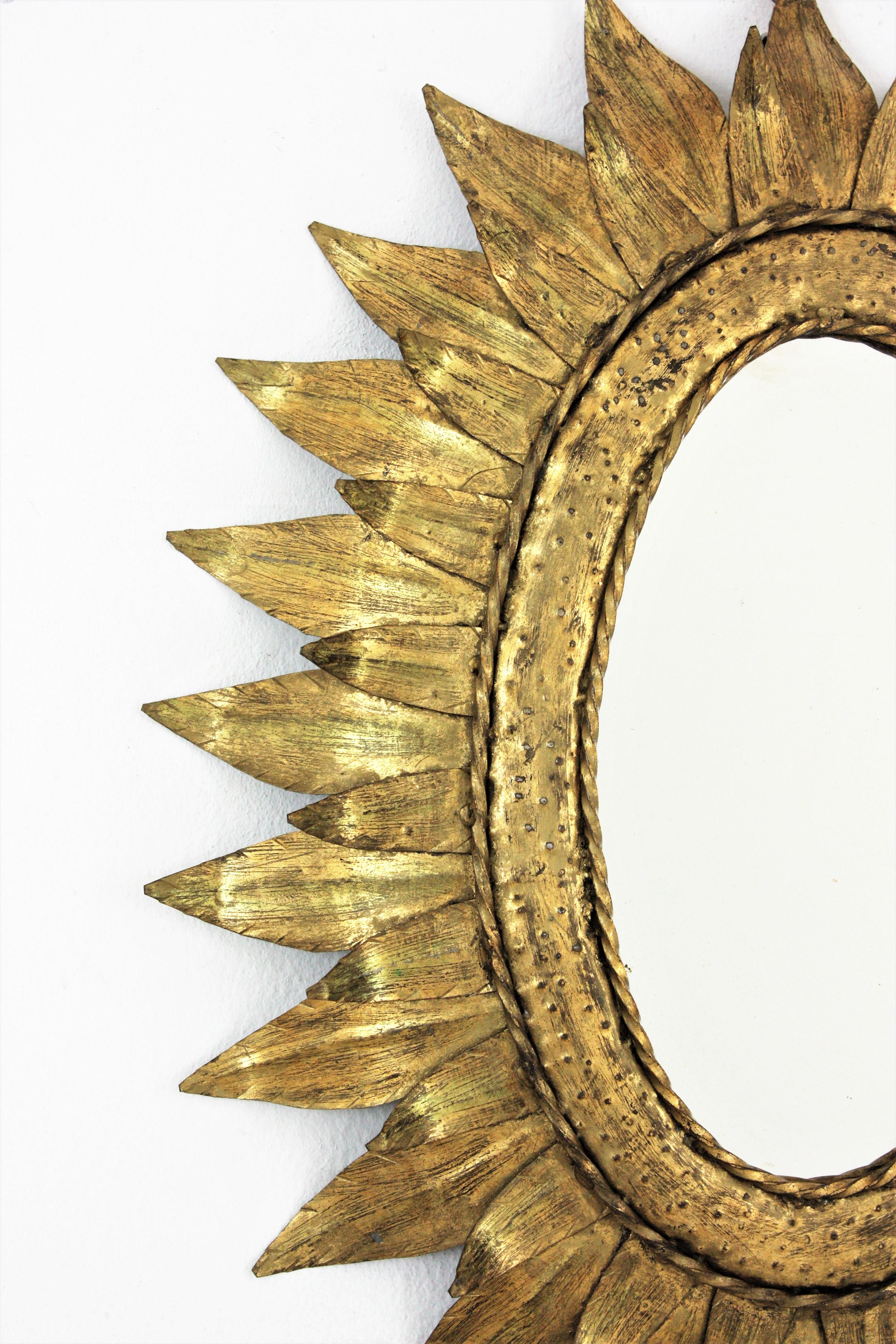 20ième siècle Miroir ovale en métal doré avec encadrement à deux feuilles en vente