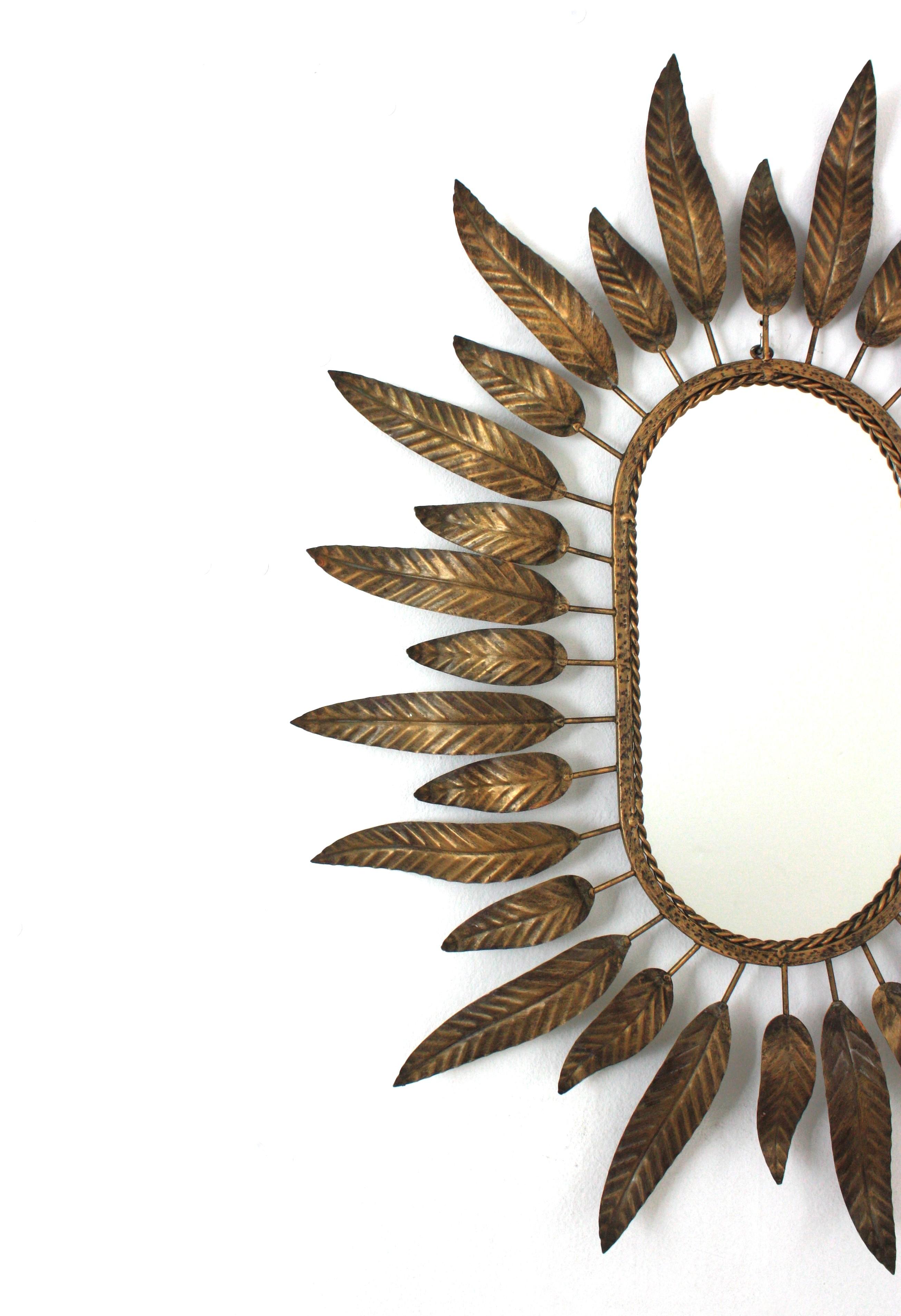Espagnol Miroir ovale Sunburst en métal doré avec cadre à feuillage en vente
