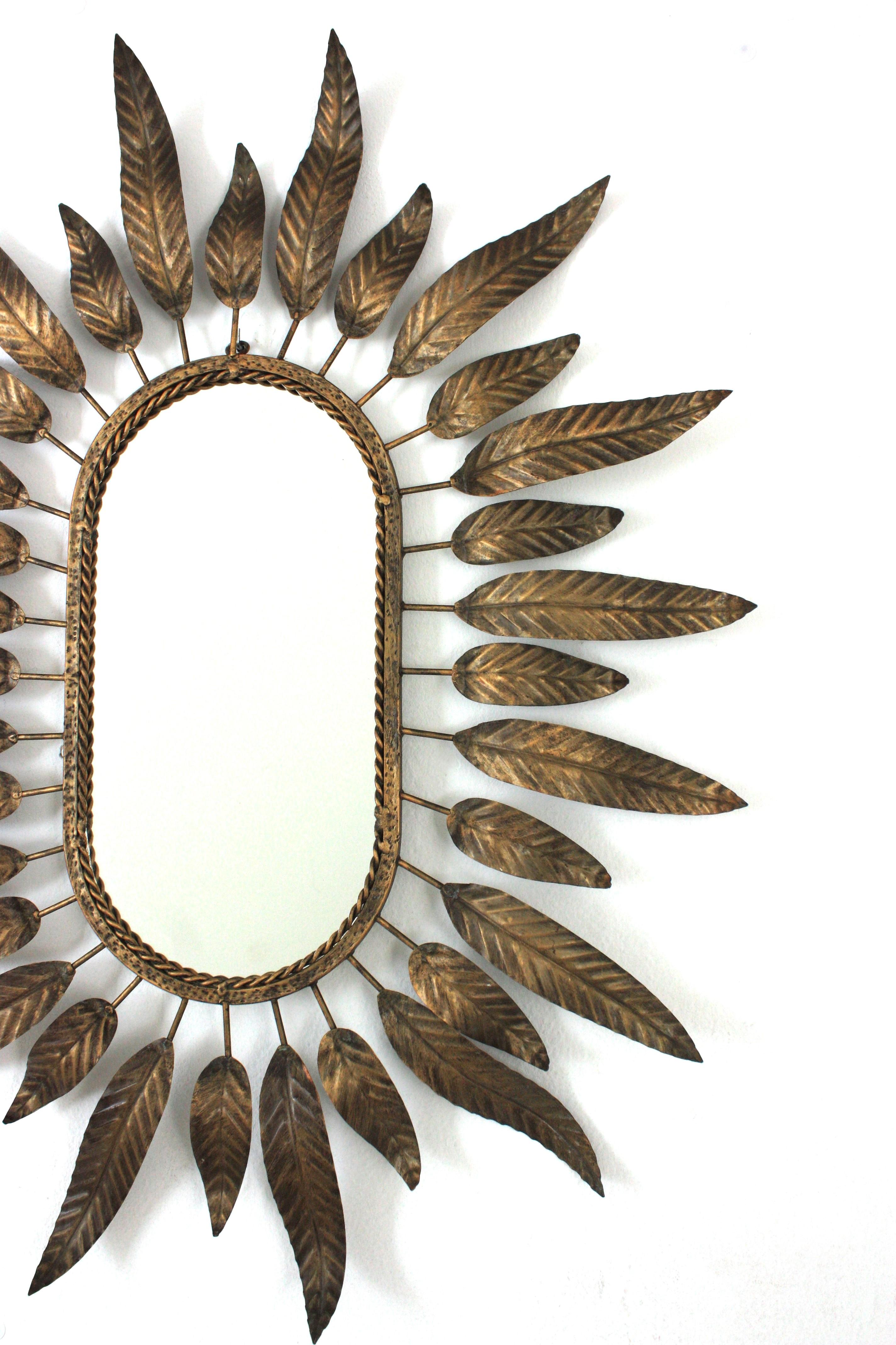 Ovaler Sonnenschliff-Spiegel aus vergoldetem Metall mit Blattwerkrahmen (Vergoldet) im Angebot