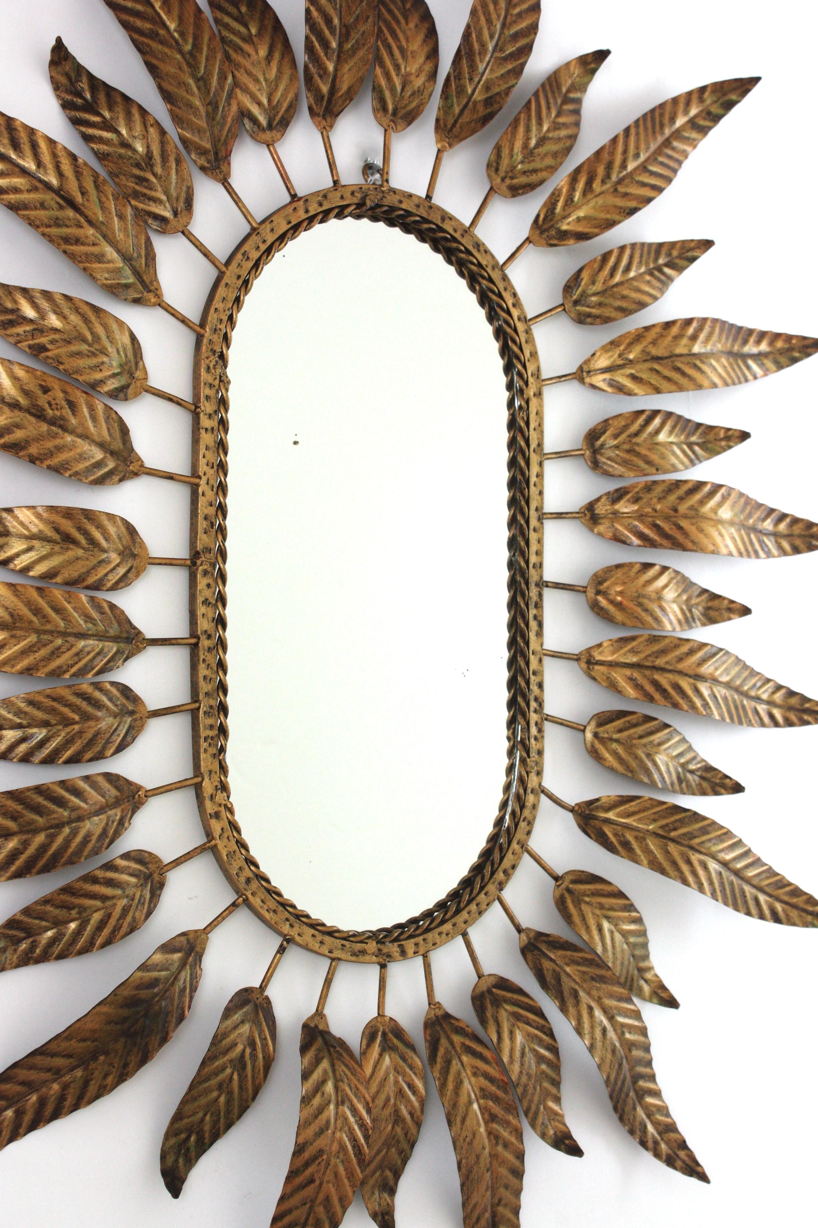 Dorato Specchio ovale Sunburst in metallo dorato con cornice fogliacea in vendita