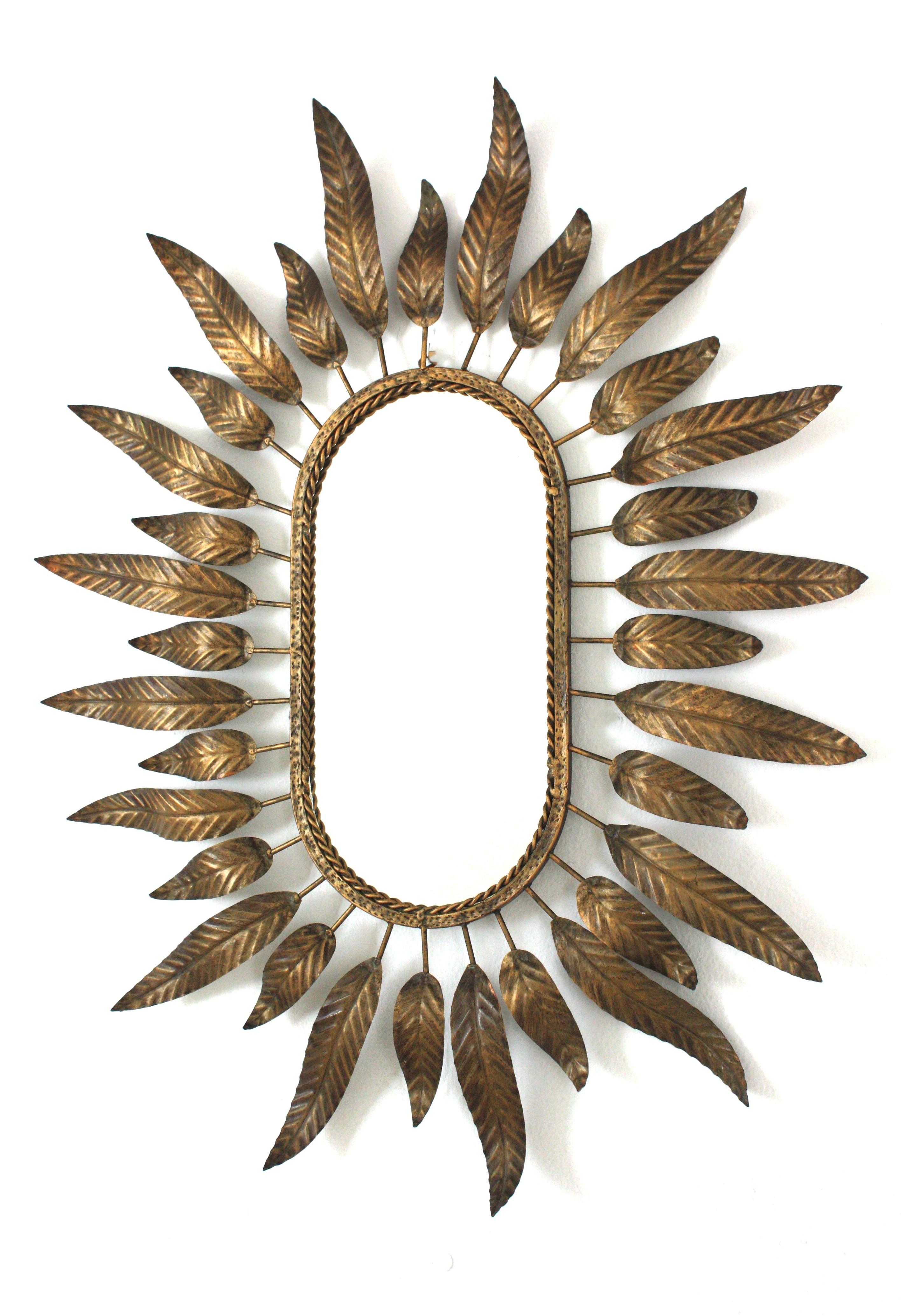 20ième siècle Miroir ovale Sunburst en métal doré avec cadre à feuillage en vente