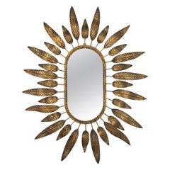 Espejo oval Sunburst de metal dorado con marco de follaje