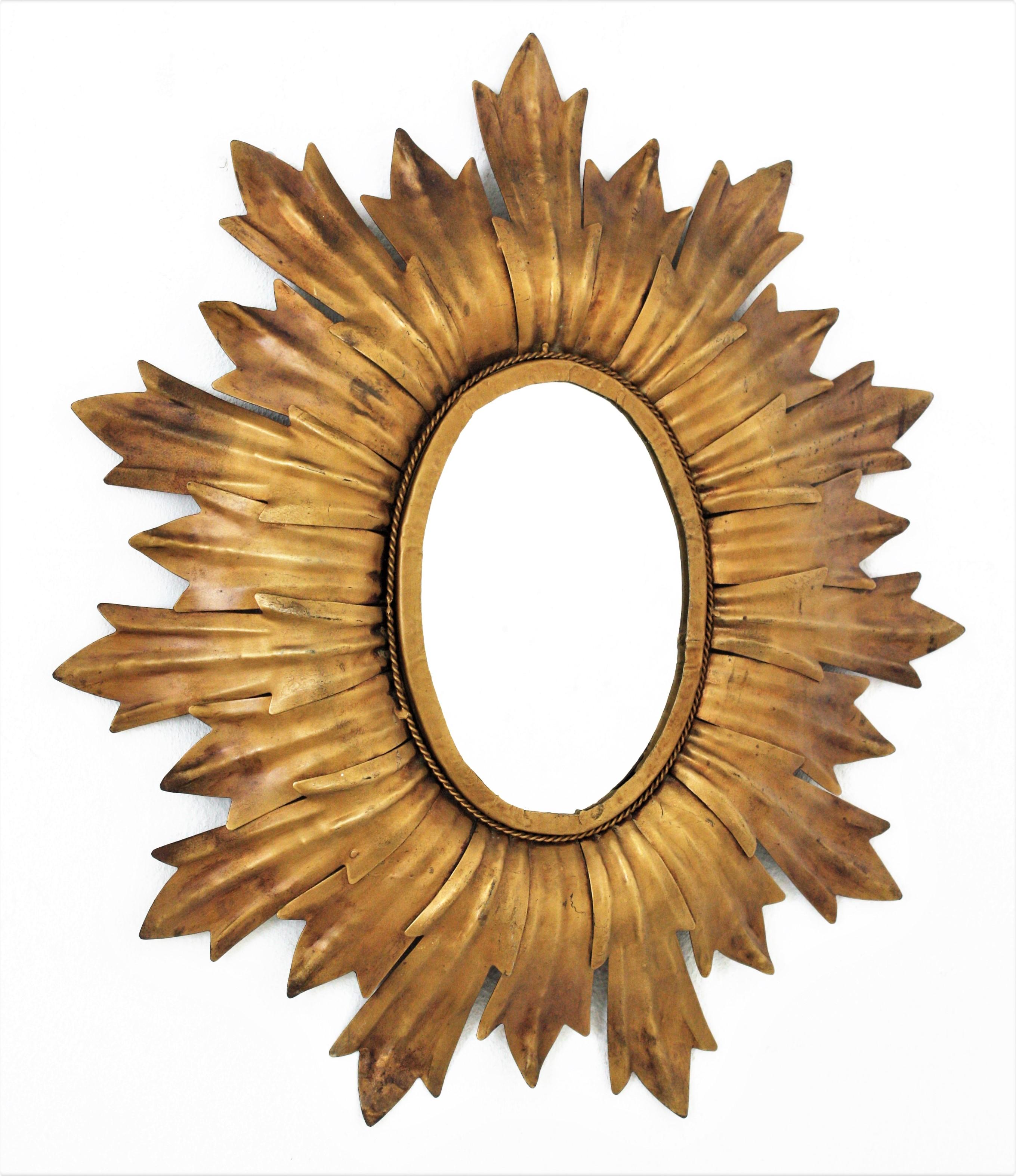 Oval sunburst mirror, Gilt iron. France, 1960s
This hand-hammered iron sunburst wall mirror features a leafed oval frame surrounding the glass
It has a nice patina showing its original gilt finish.
The design combining Hollywood Regency and