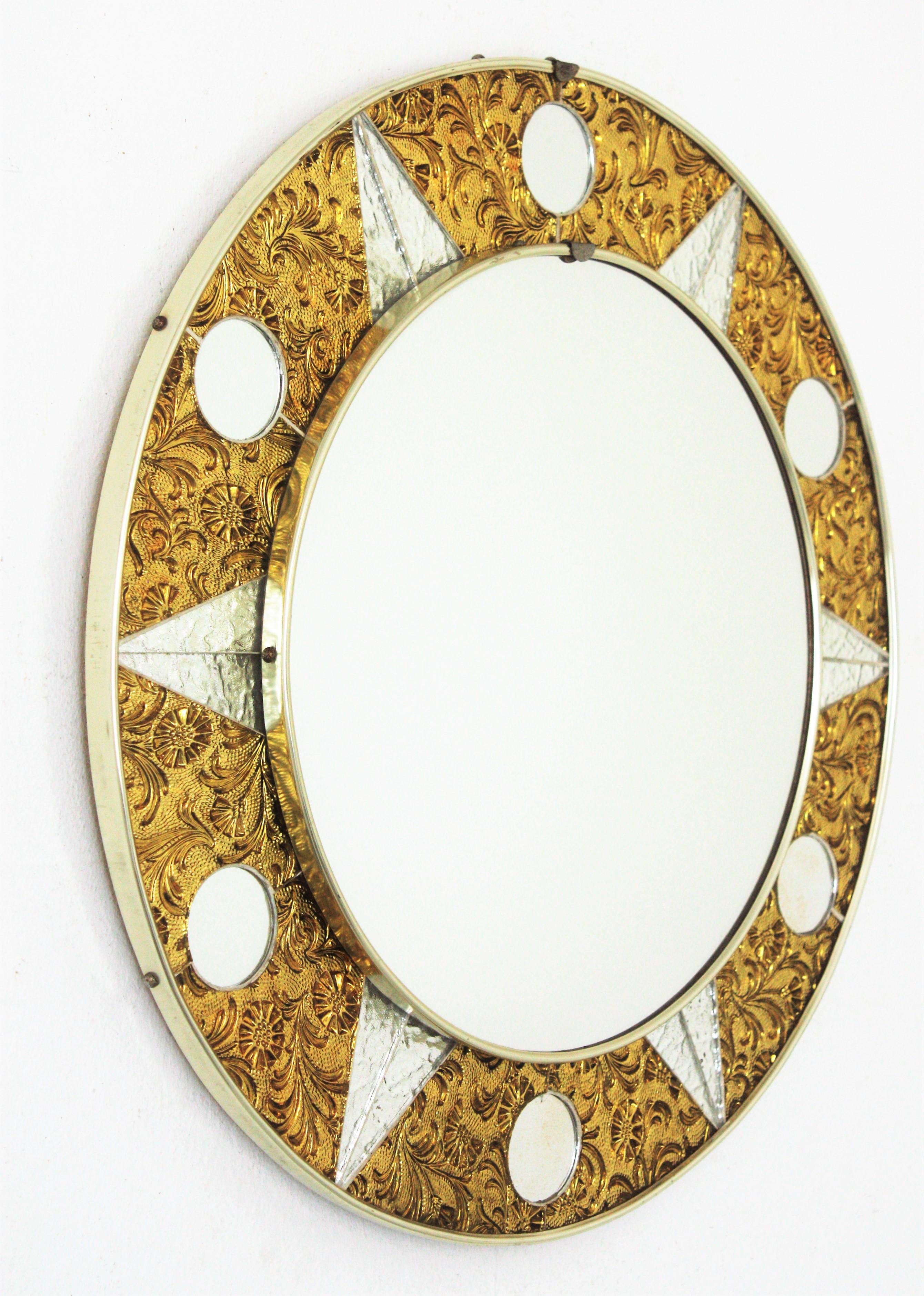 Spanish Mid-Century Modern sunburst glass mosaic round mirror. Spain, 1950-1960s
This mirror features a beautiful round mosaic sunburst mirror with golden textured glasses accented by mirrored glasses
This sunburst mirror will be a nice Midcentury