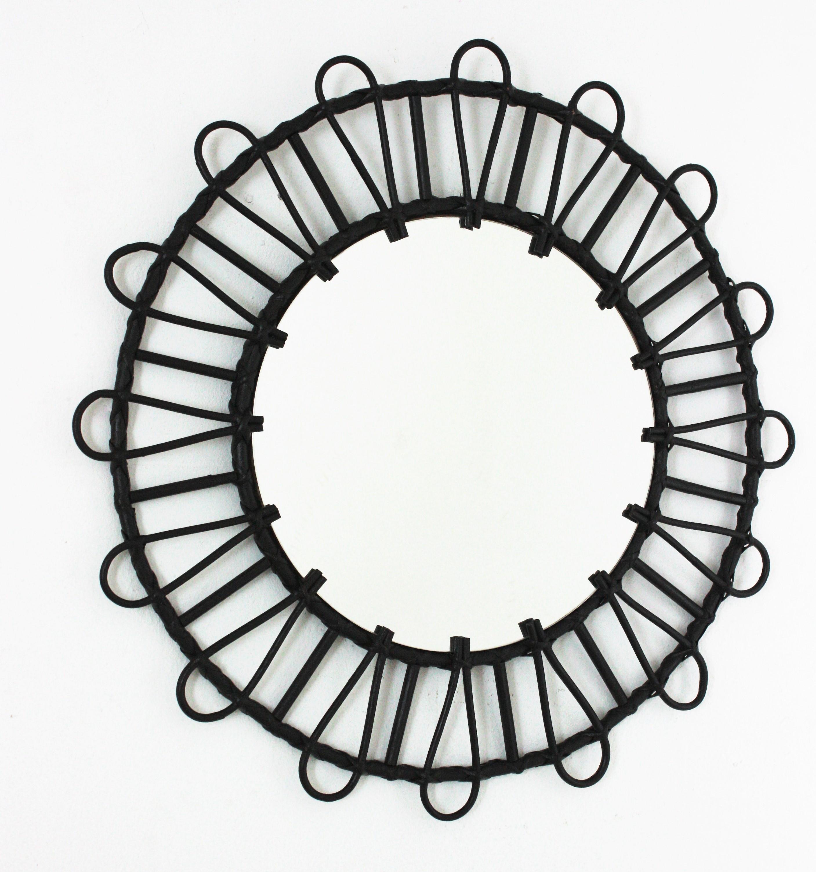 Black Mid-Century Modern Rattan mirror, Spain 1960s.
This handcrafted mirror features a round rattan frame with loop decorations placed in sunburst disposition.
This wall mirror would be a nice addition in a contemporary or classical ambiance.