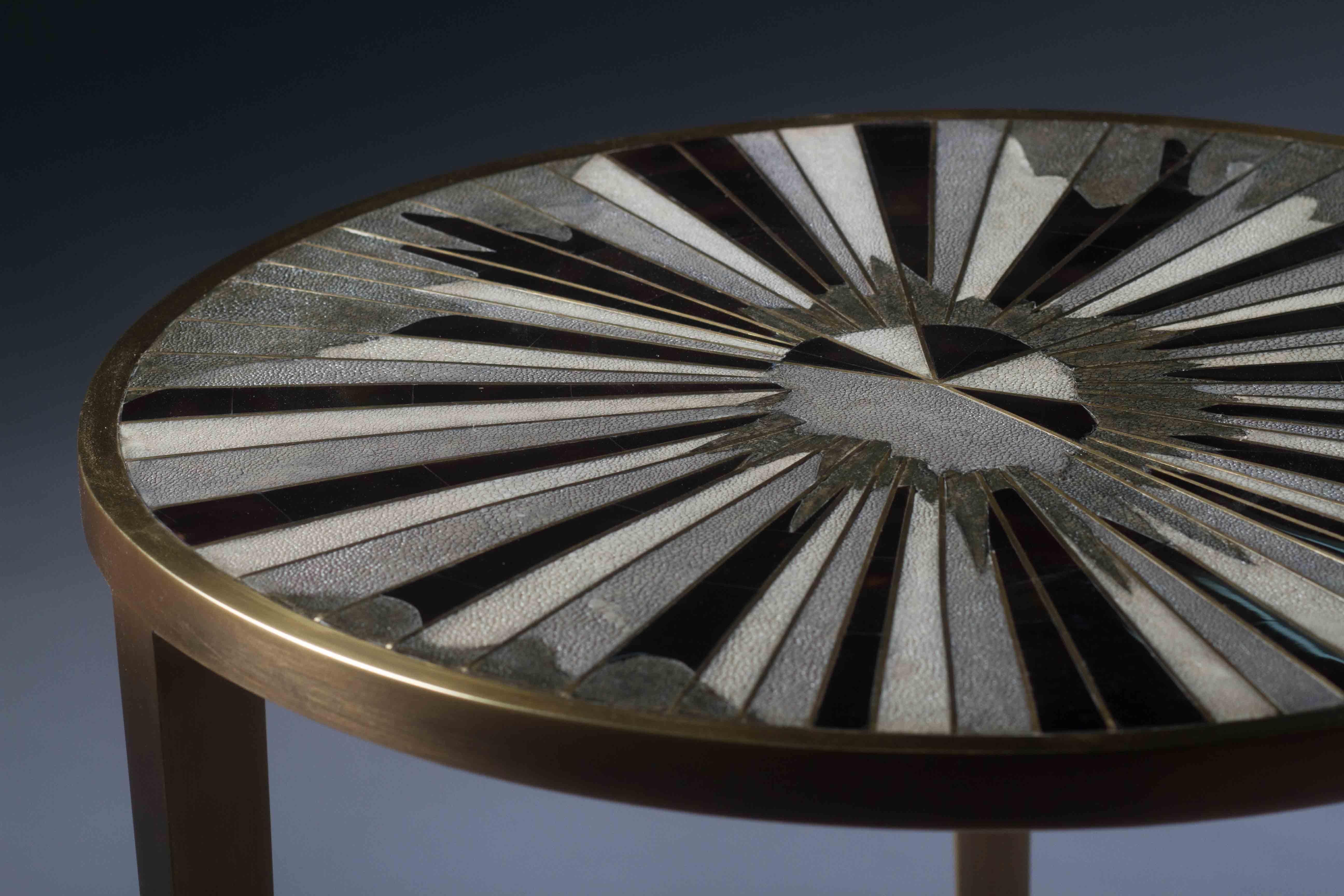 La table d'appoint Sunburst de R&Y Augousti témoigne de l'habileté de leur travail artisanal d'incrustation d'une combinaison de galuchat crème, noir et bleu, mélangé à des bandes de coquille de stylo noir et de laiton bronze-patina pour créer ce