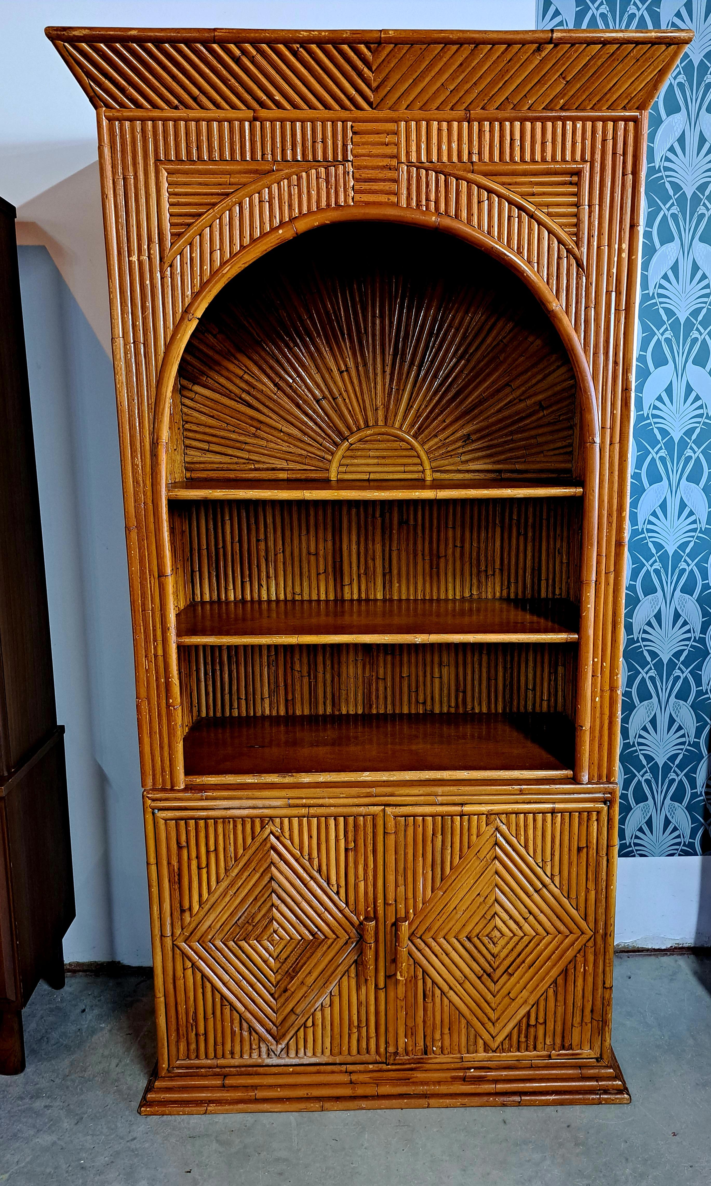 Sunburst split reed bamboo cabinet in excellent vintage condition. This piece would work well with mid-century, Hollywood Regency, and Palm Beach styles. It is finished all the way around, so it would make a great piece to fit either on a wall or in
