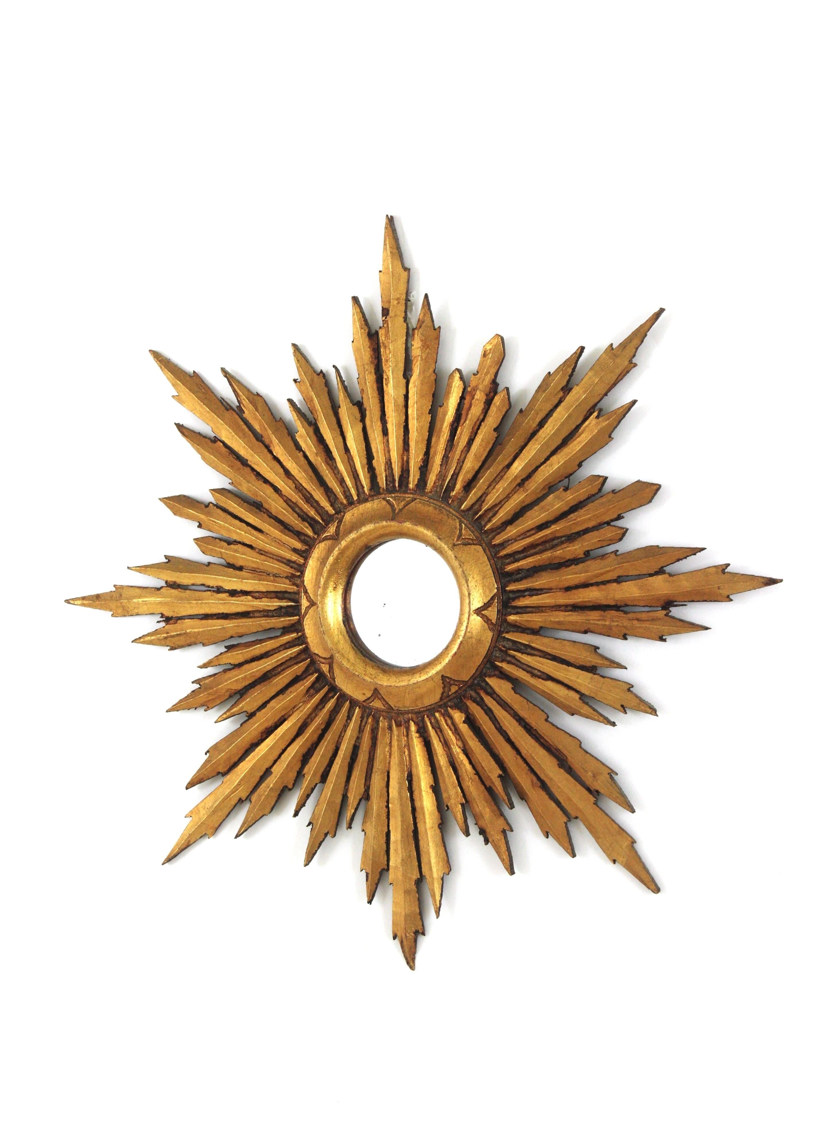 Spanish Baroque Style Giltwood Sunburst Mirror , 1940s-1950s
Lovely Baroque style small sized giltwood sunburst mirror with gold leaf finish. 
This gorgeous mini size sunburst mirror has a frame comprised by rays in different sizes and a ring frame