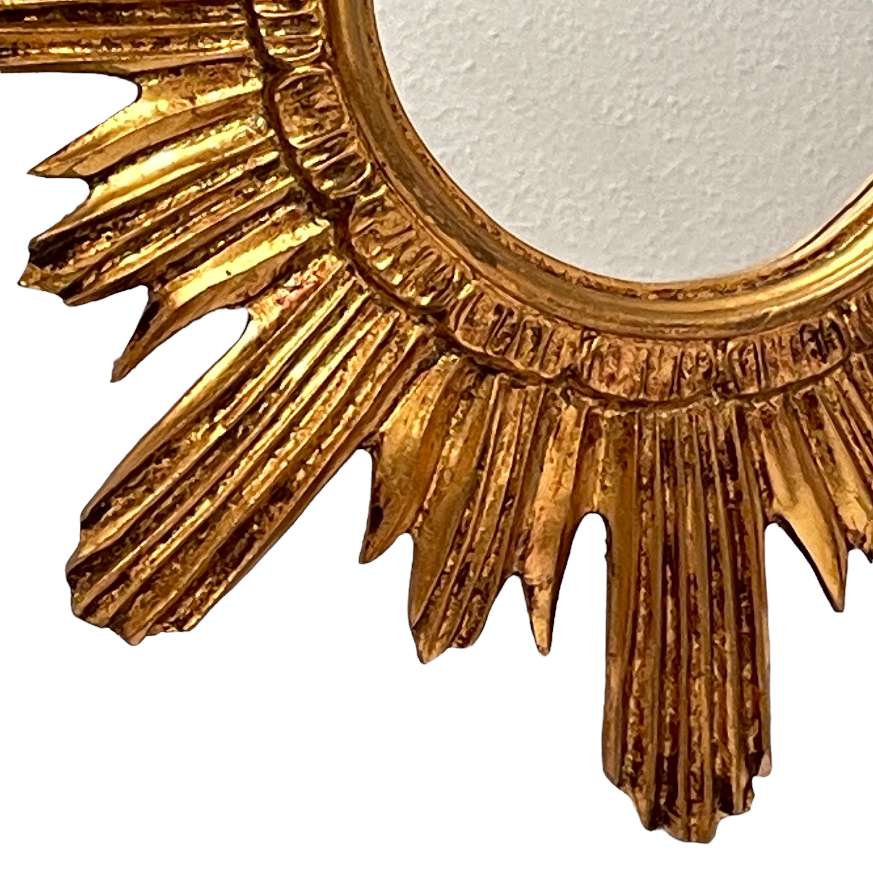 Un magnifique miroir en étoile. Fait de bois doré et de stuc. Aucun éclat, aucune fissure, aucune réparation. Il mesure environ 16,88 pouces de diamètre, le miroir lui-même mesurant environ 5,75 pouces de diamètre. Il se tient à environ 1.5
