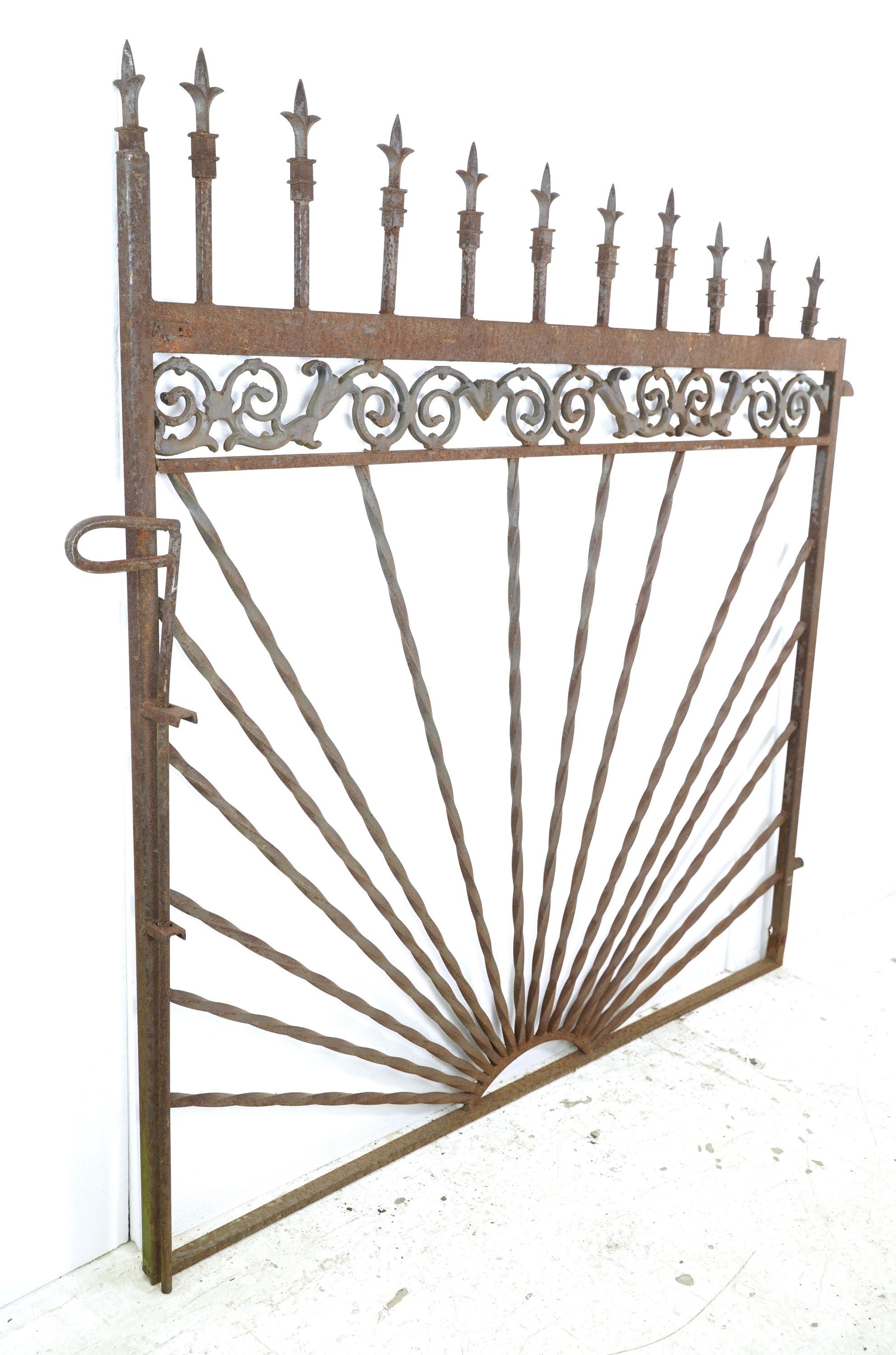 Twisted wrought iron spindles and cast iron scrolls and finials wielded together make up this decorative garden gate. Simply install it in your desired outdoor area connecting to your existing fence. It serves as an entrance or barrier, providing