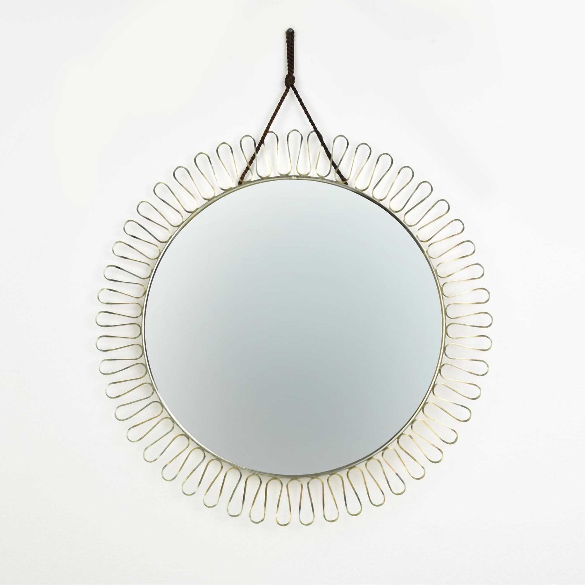 A vintage brass framed mirror with wire loop rim designed by Josef Frank for Svensk Tenn is a beautiful piece of home decoration. The mirror itself is surrounded by a wire loop rim that adds a touch of elegance to the design. The frame of the mirror