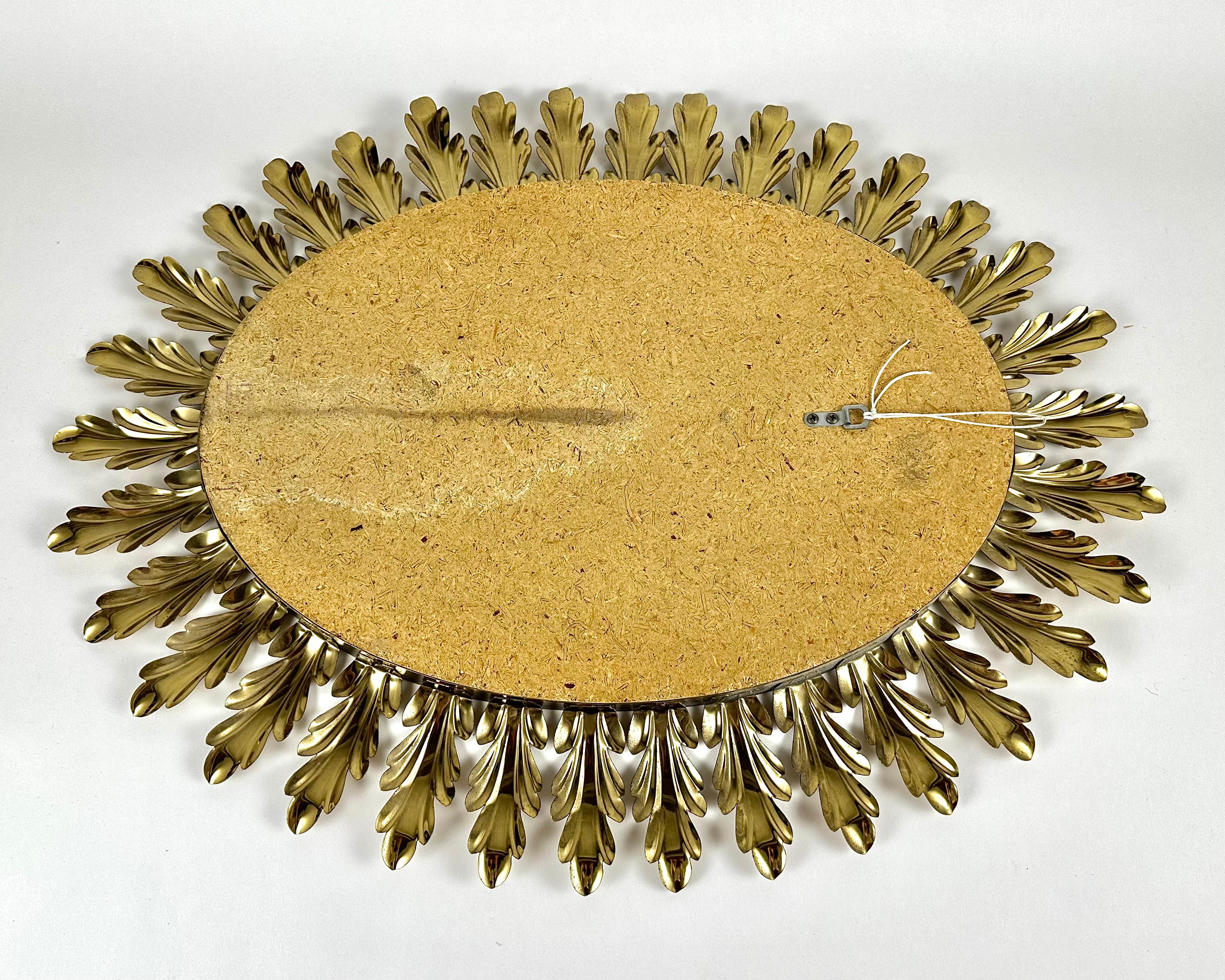 Sunburst vintage wall mirror with beautiful floral decoration gilt metal frame.

Belgium. 1970s.

This exquisitely hand-carved metal-framed wall mirror is infused with a sumptuous leafy motif.  

Our impressively sized handcrafted mirror is a
