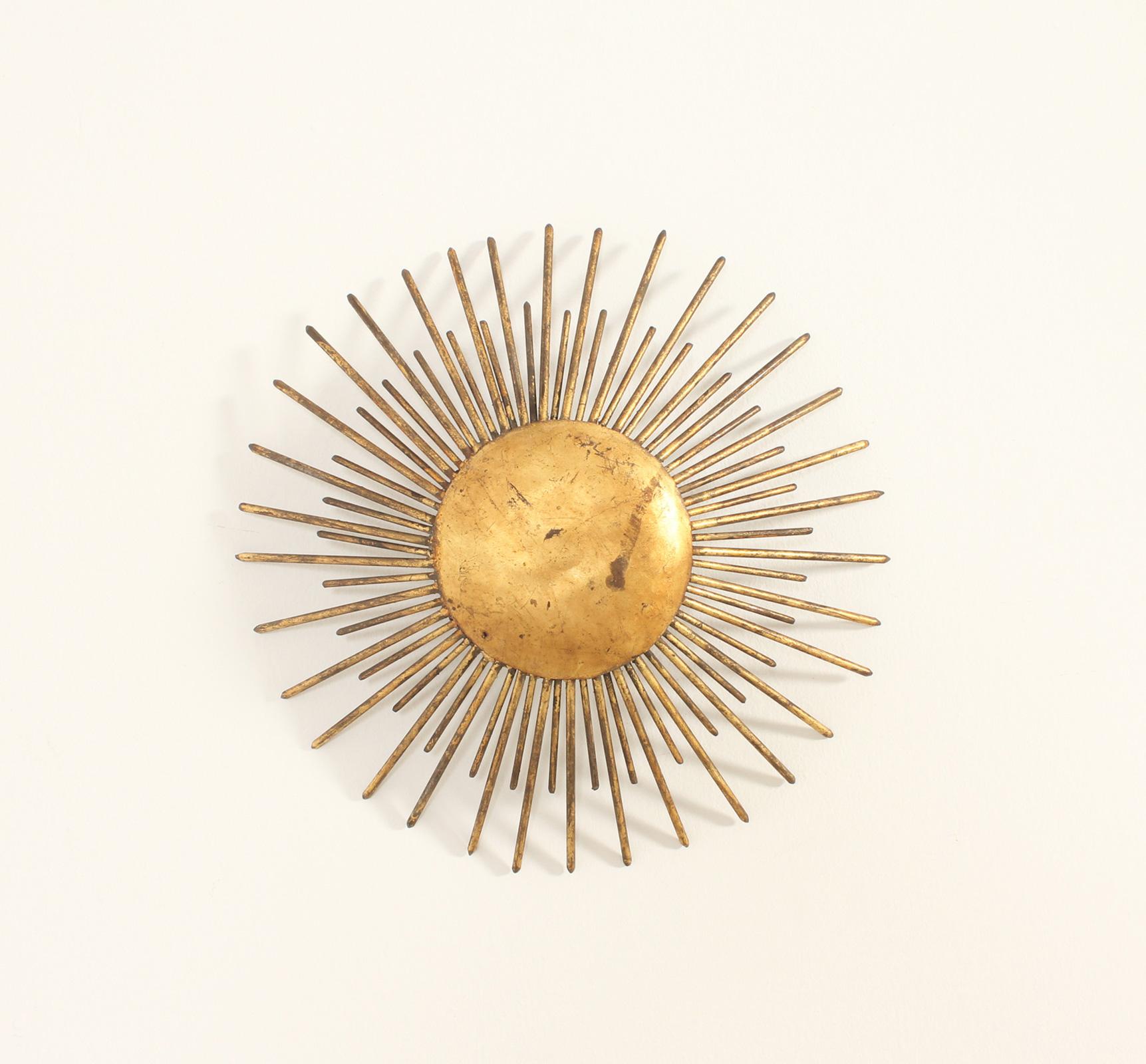Sunburst wall or ceiling lamp from 1940's, France. Hand hammered gilt forged iron with two bulbs, it can be used as a ceiling or wall lamp.