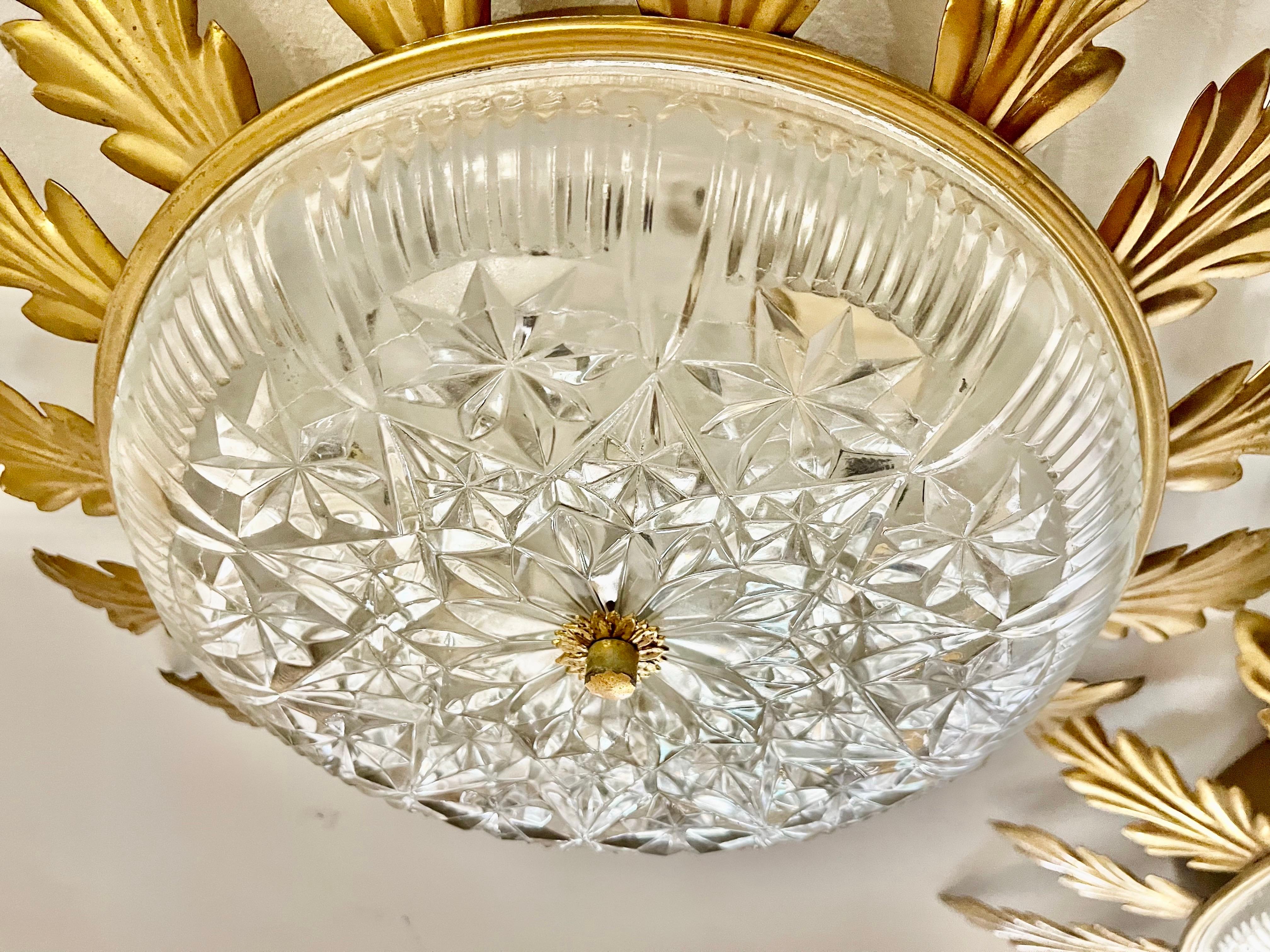 Iconic sunburst lamp in guilt gold metal with two E27 lights in the center. Handcrafted and hammered iron finished in gold leaf with a nicely aged patina. with crystal glass

This functionality can be used as recessed mounting or as a wall element.