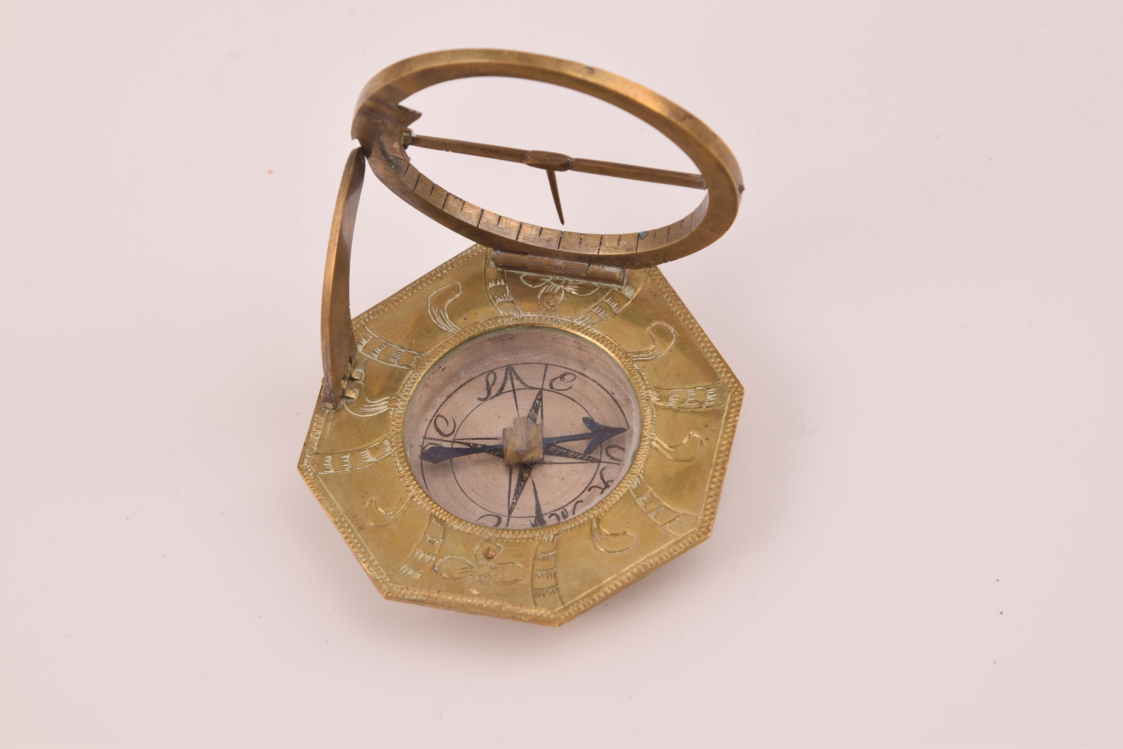 Sundial and compass with case. Bronze. SCHRETTEGGER, Johan. Augsburg, Germany, around 1800. 
Sundial with a polygonal shape made of bronze, engraved with plant elements on the front, located around the center, where a compass is presented. On the