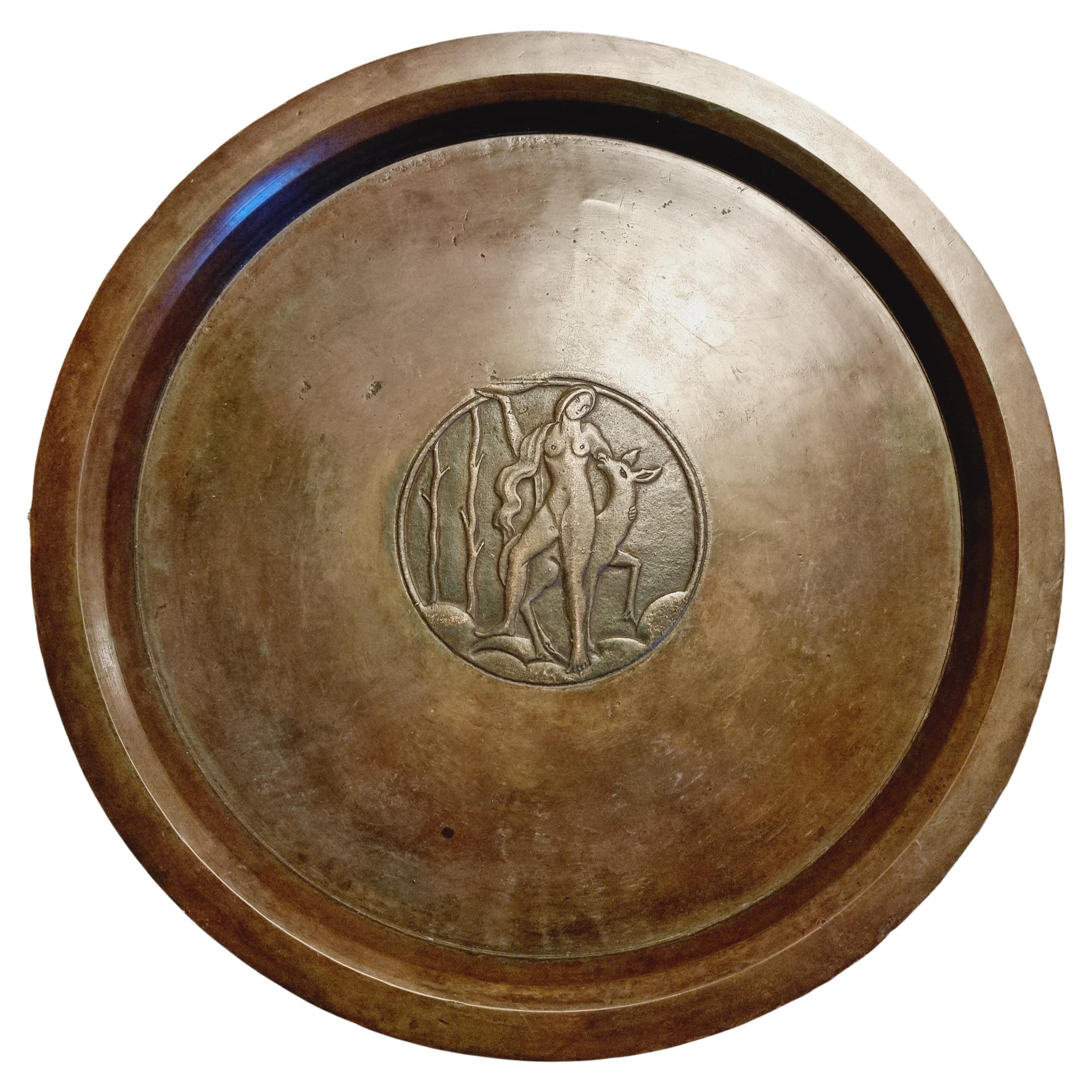 Rare solid bronze platter with decor of goddess of the wild and hunt Diana with a dear. Marked Sune Bäckström, Brons, 9032. 

Diam. 38.5 cm. 

Normal signs of age and wear. A few older, small dents, could be from manufacturing.