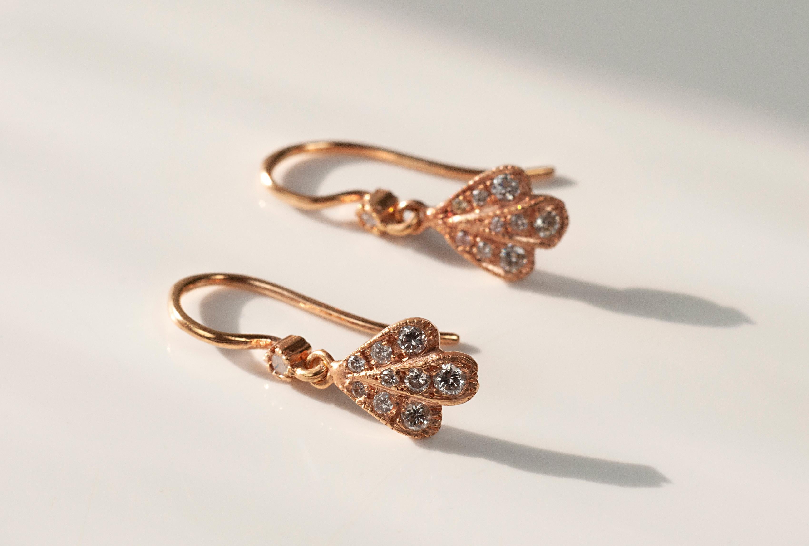 Rose gold flower petal drop earrings with white diamonds 0.22cts and french earwire. This pair of floral-inspired earrings show the Indian design influences of the designer while remaining clearly contemporary.
