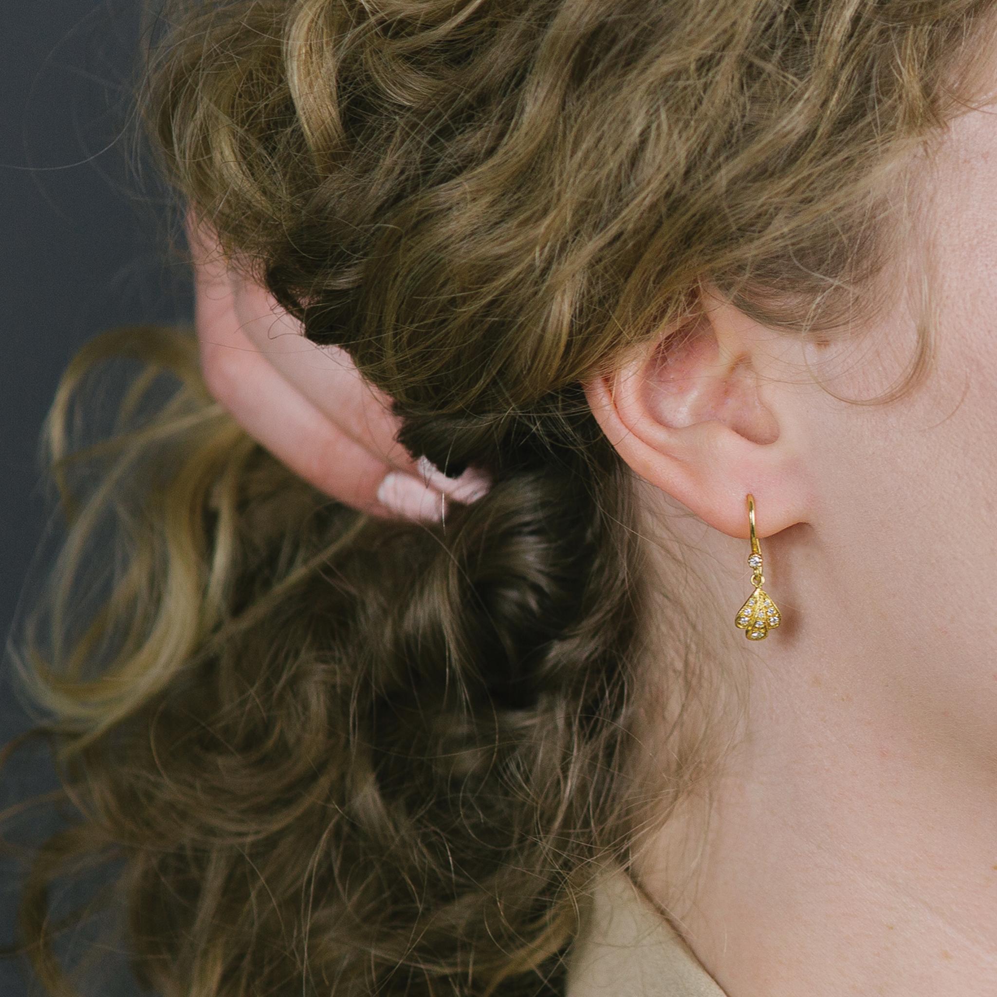 Yellow gold flower petal drop earrings with white diamonds 0.22cts and french earwire. This pair of floral-inspired earrings show the Indian design influences of the designer while remaining clearly contemporary.
