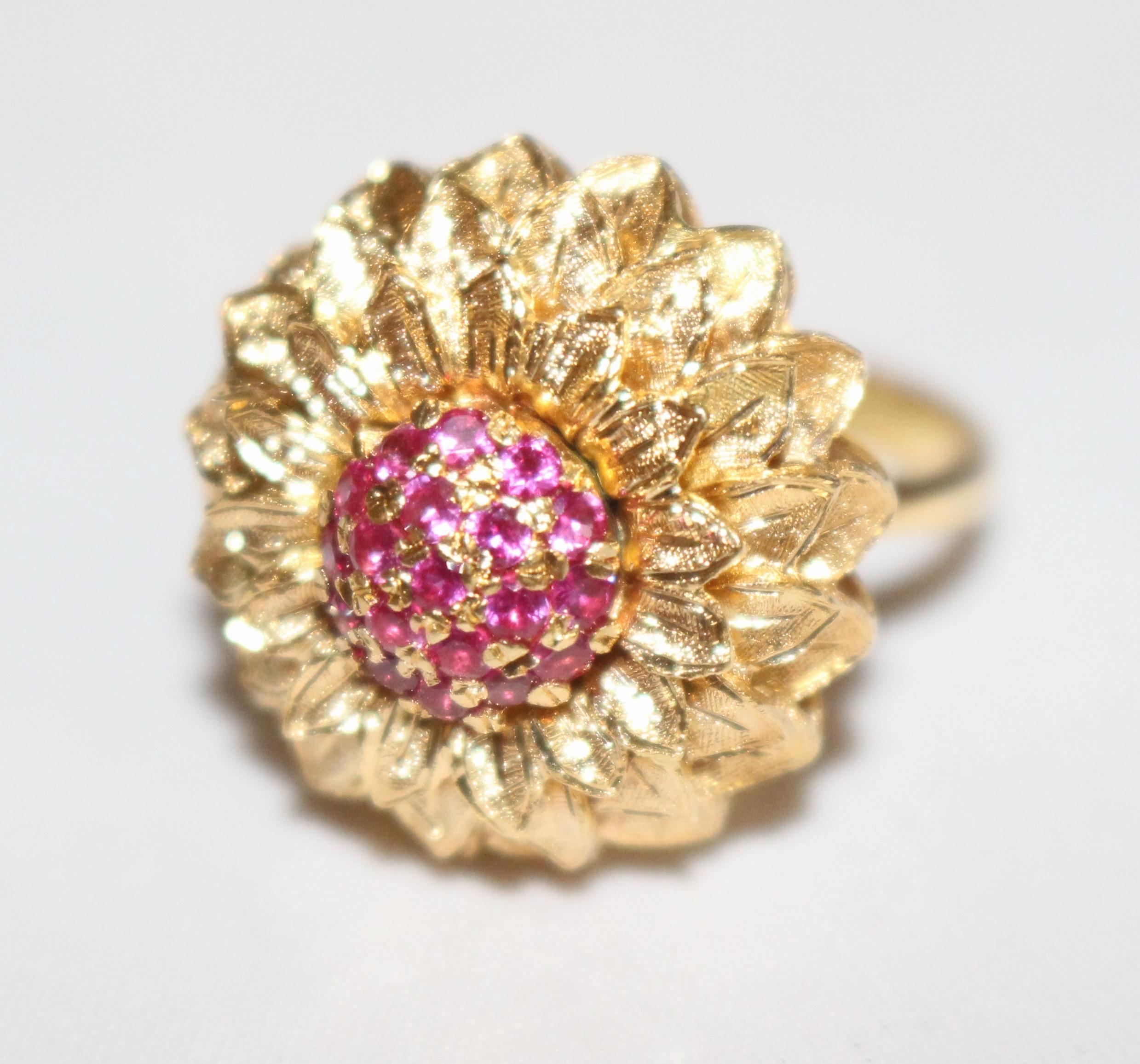 Stones 19 dark pink rubies, total ruby weight 0.40 carat
Gold 18-carat yellow gold, marked 750
Ring size J 1/2 (British), 5.25 (USA)
Gross item weight 10.6 g
Condition: Very good condition. 




Very stylish sunflower design pink ruby