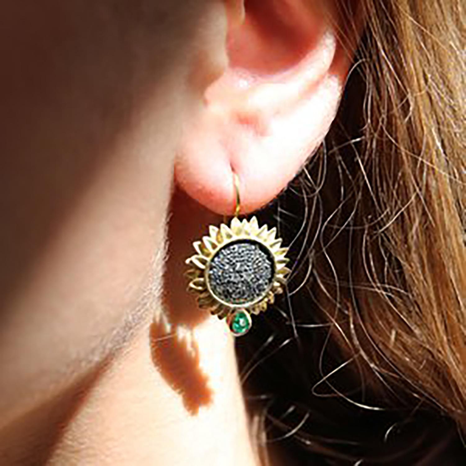 These sparkly sunflowers are even more eye-catching than the real thing!
Our sunflower earrings have 18k yellow gold petals surrounding oxidized silver with pave-set diamonds. The earrings are adorned with a matched set of  pear shaped emeralds,