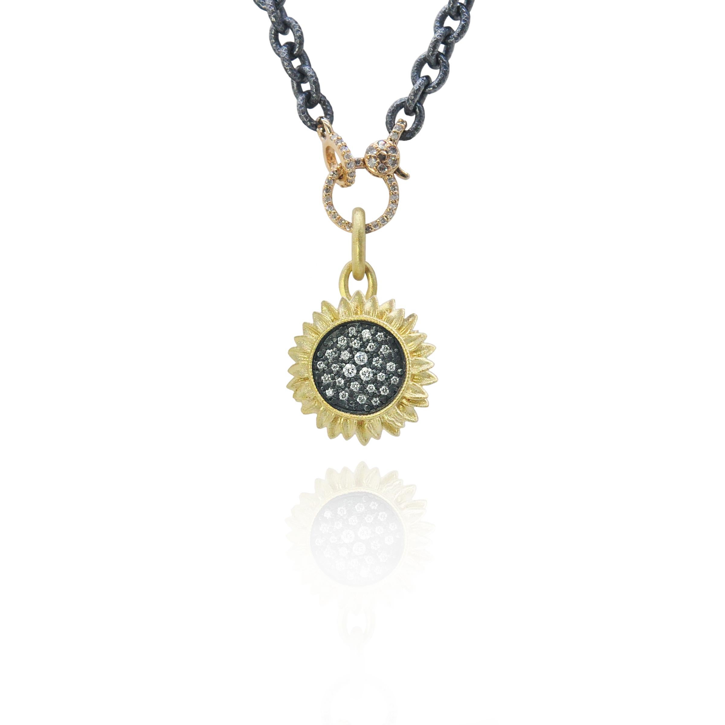 These sparkly sunflowers are even more eye-catching than the real thing!
Sunflower pendants and earrings have 18k yellow gold petals surrounding oxidized sterling silver pave-set diamonds. The gold charm holder clasp on the piece is pave set with