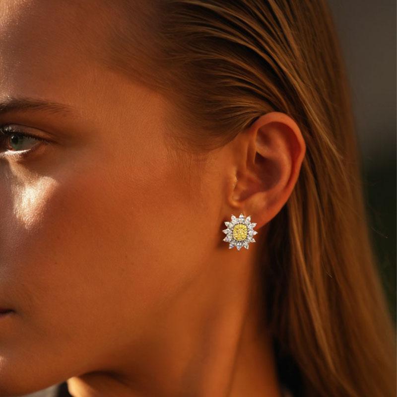 Illumina il tuo stile con questi orecchini mozzafiato ispirati ai girasoli, che mostrano un brillante diamante giallo centrale circondato da diamanti bianchi meticolosamente disposti. Incastonate in oro bianco 14 carati, queste borchie floreali
