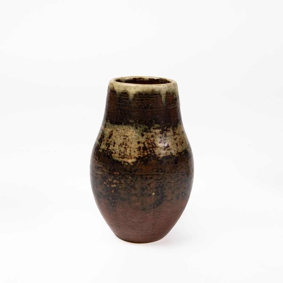 Magnifique vase de caractère en grès, créé par Kresten Bloch pour Royal Copenhagen.
Décorée d'une glaçure Sung vibrante et profonde dans des tons chauds de terre, avec des nuances de brun, de beige et d'olive, qui donnent à la surface une expression