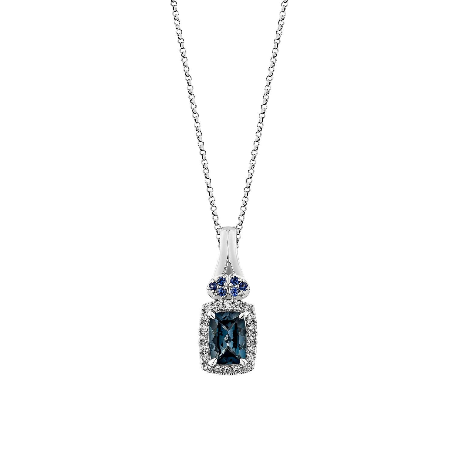 This captivating pendant features a striking cushion-cut London Blue Topaz set in 14K white gold, radiating deep oceanic hues. Framed by a halo of brilliant white diamonds and complemented by vibrant blue sapphire accents, the design exudes a