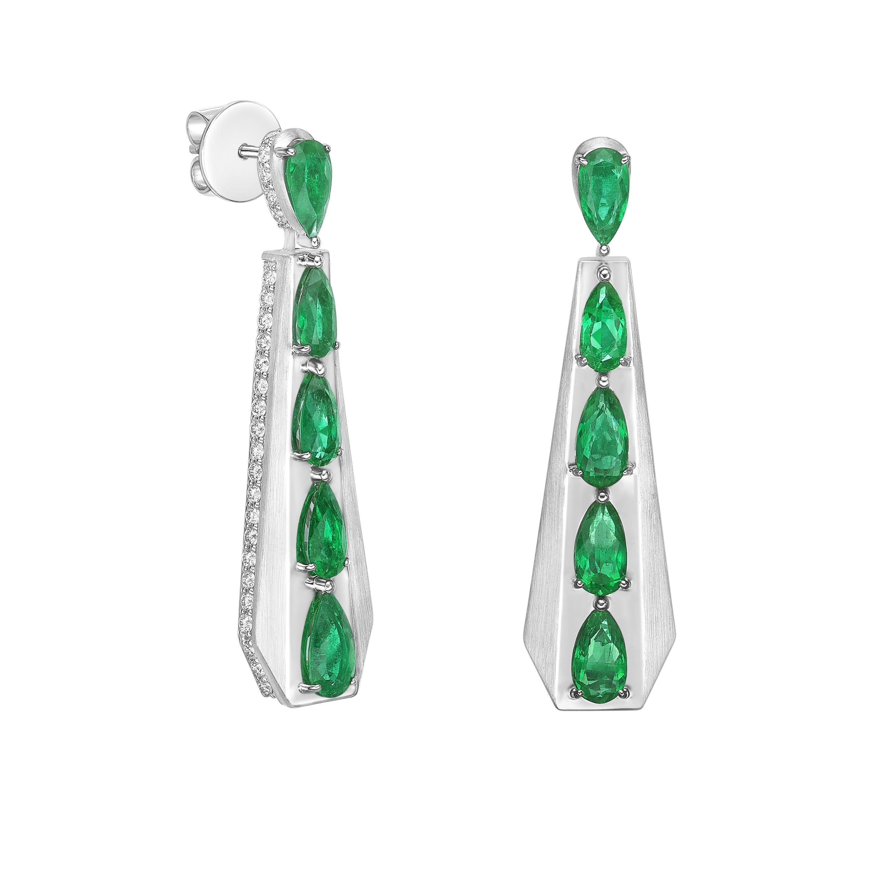 Moderni orecchini a goccia in oro bianco 18 carati dal design elegante e affusolato, con una fila graduata di smeraldi rotondi e scintillanti diamanti bianchi nella parte superiore. Un equilibrio sorprendente di colore ed eleganza, perfetto per la