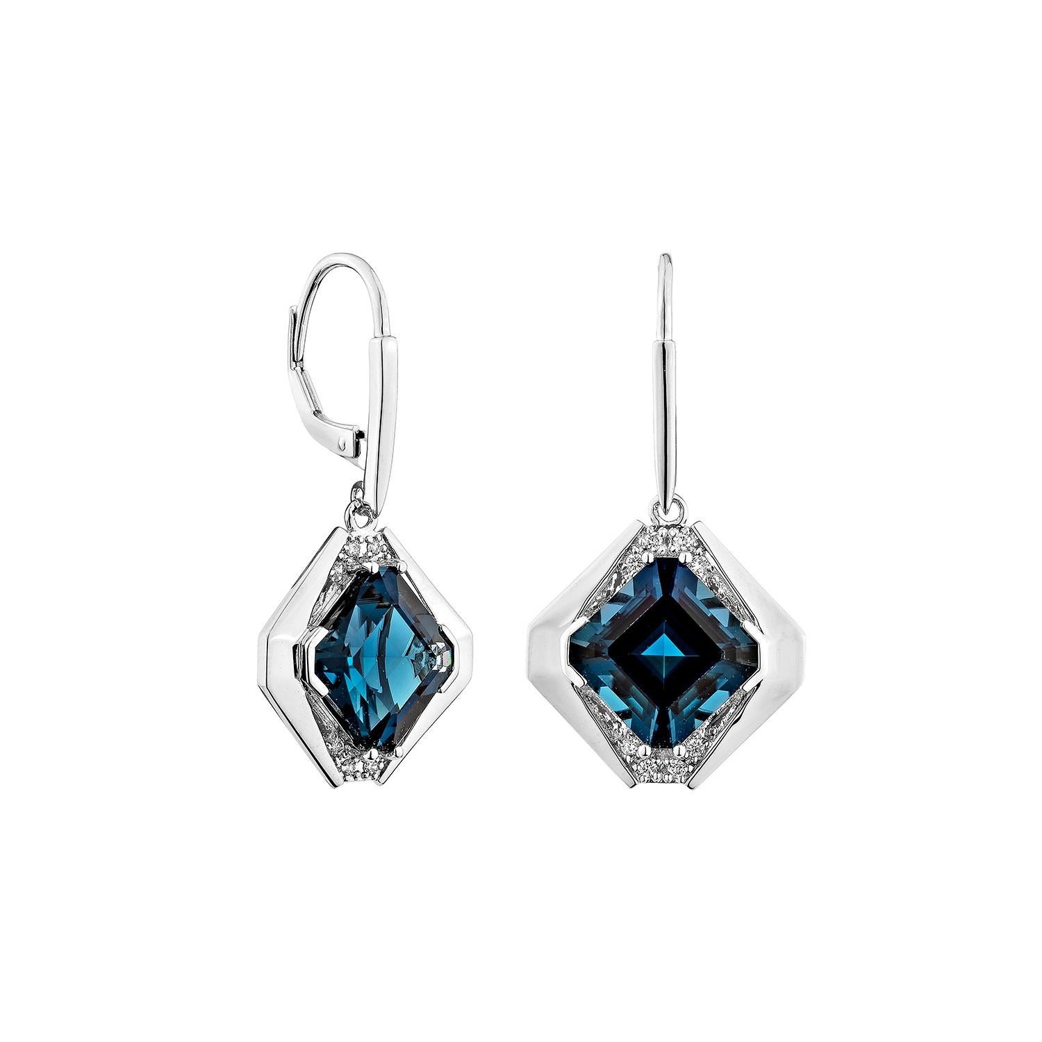 Sofisticados y cautivadores, estos pendientes colgantes presentan gemas de topacio azul de Londres de forma octogonal, elegantemente combinadas con brillantes diamantes blancos. Fabricadas en oro blanco de 14 quilates, ofrecen un encanto atemporal