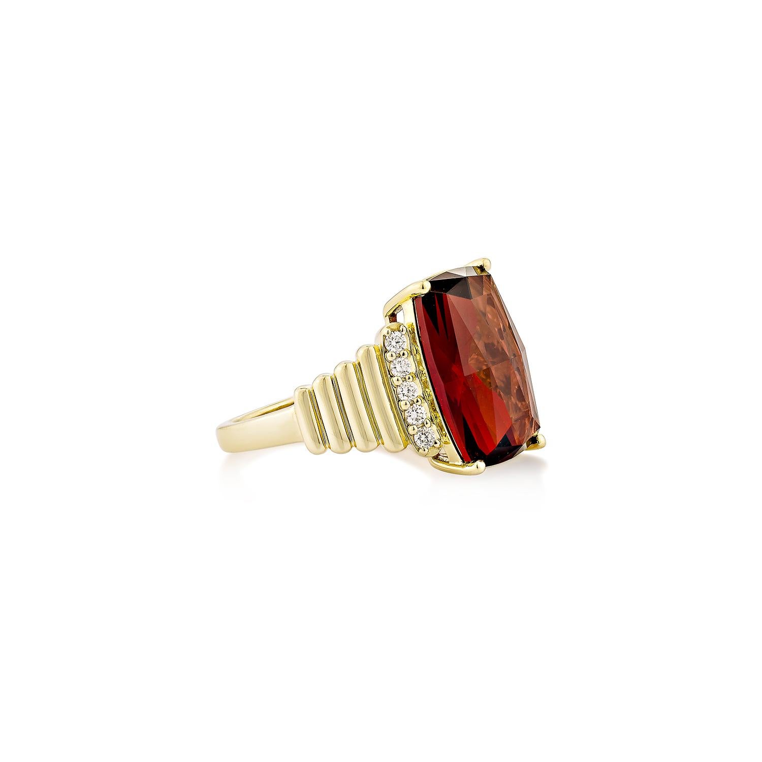 Un anillo atrevido y sofisticado que exhibe un llamativo granate rojo talla cojín, acentuado por brillantes diamantes a lo largo de una banda esculpida de oro amarillo de 14 quilates. Este diseño atemporal combina el encanto vintage con la elegancia